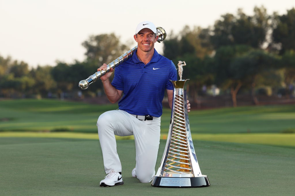 Rory McIlroy poses with the DP World Tour Championship trophy (left) and the Race to Dubai trophy on the 18th green following victory at Jumeirah Golf Estates, Dubai