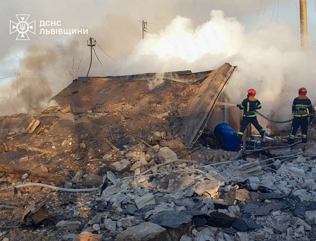 <p>Firefighters in Lviv work at the site of a residential area hit by a Russian missile strike</p>