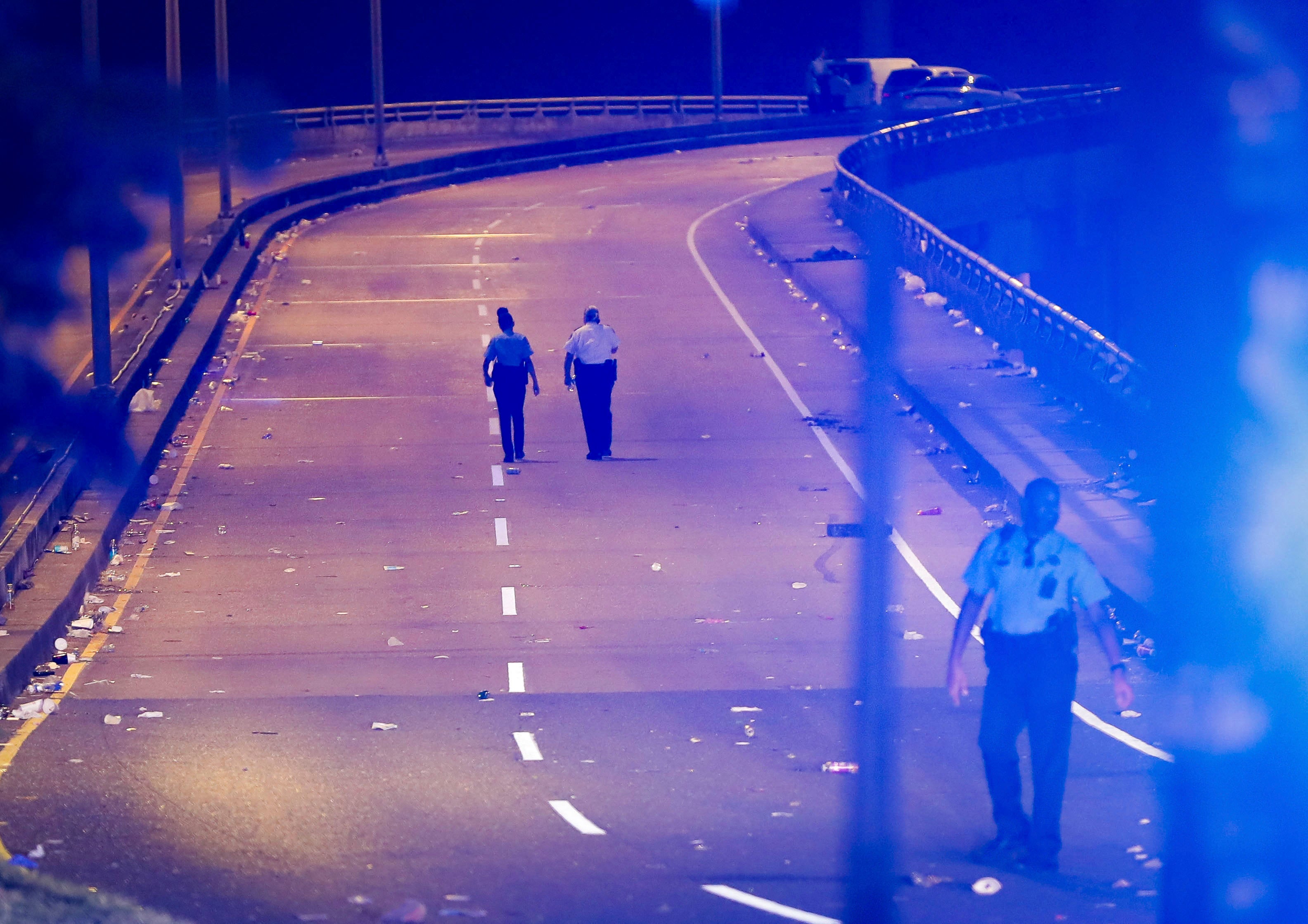 New Orleans police walk up the Almonaster Avenue bridge after a deadly shooting in New Orleans