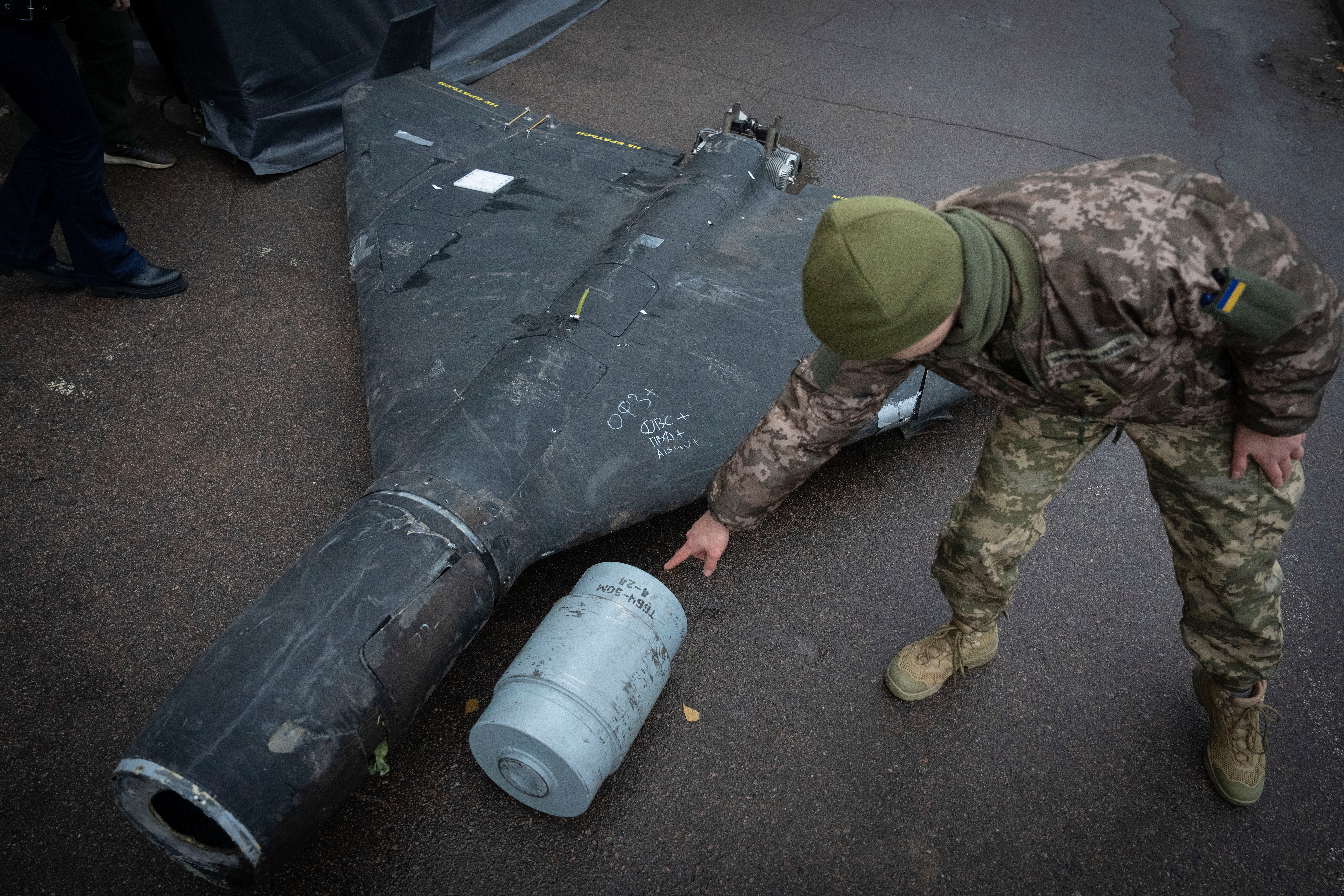 A Ukrainian officer shows a thermobaric charge of a downed Shahed drone launched by Russia in a research laboratory in an undisclosed location in Ukraine Thursday, 14 November 2024