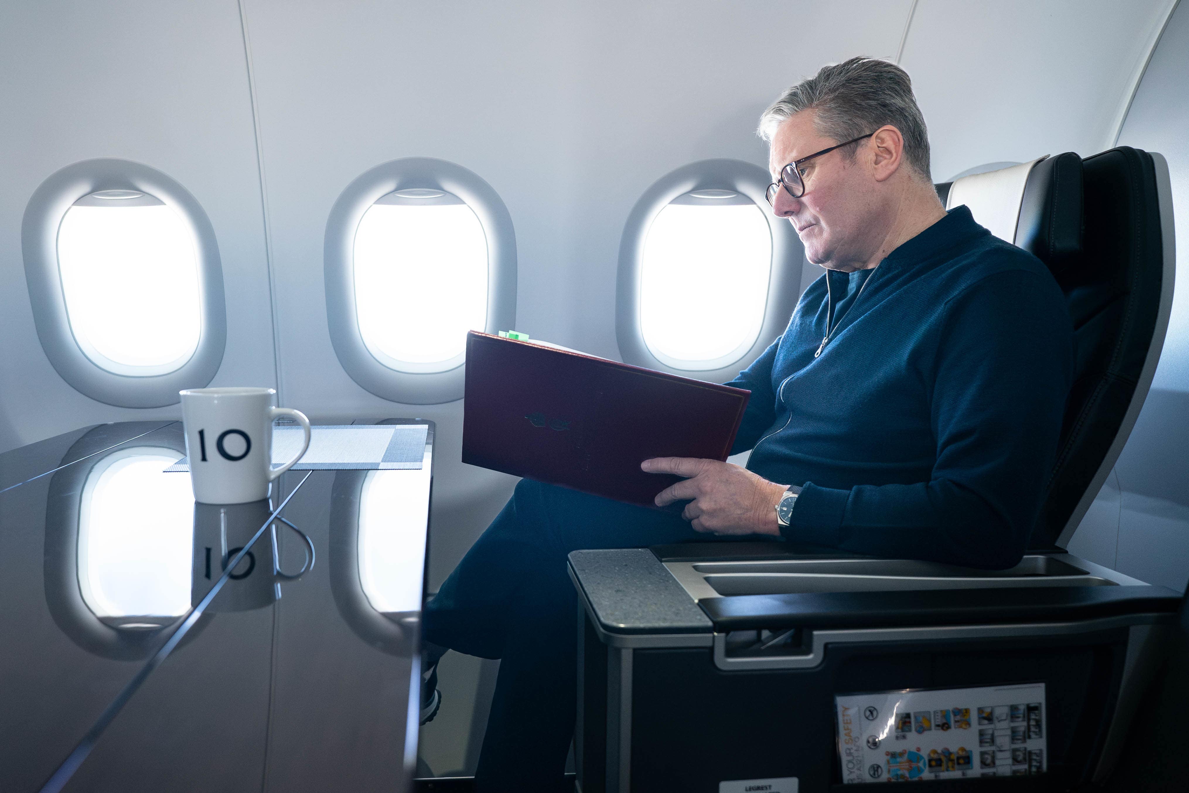 Prime Minister Sir Keir Starmer works on board a Government plane as he travels to Rio de Janeiro (Stefan Rousseau/PA)