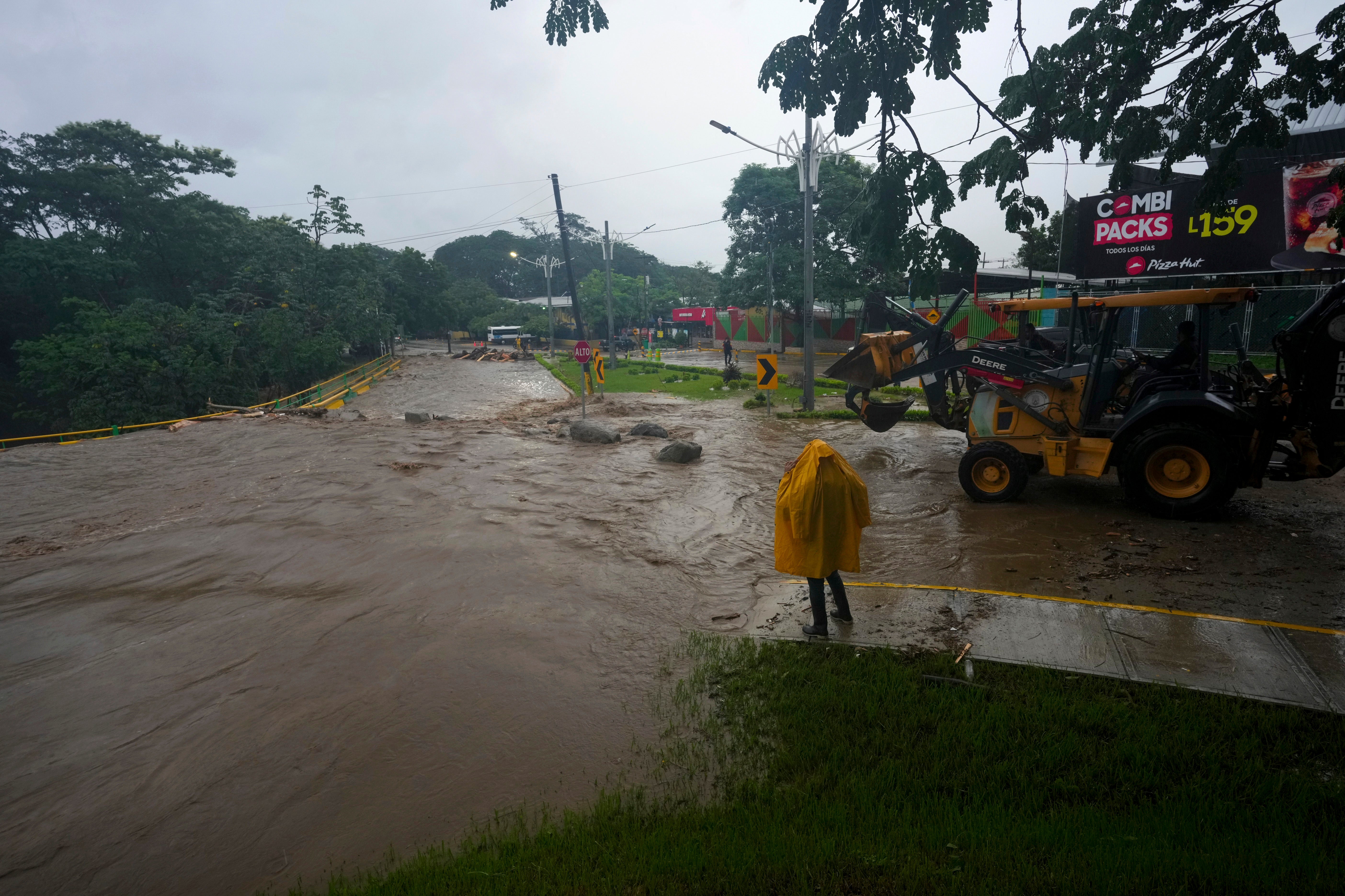 A worker stands alongside an overflowing river flooded by rains brought on by Tropical Storm Sara in San Pedro Sula, Honduras, last weekend. Honduras could see even more flooding on Monday. The Gulf Coast of the US could also feel the storm later in the week