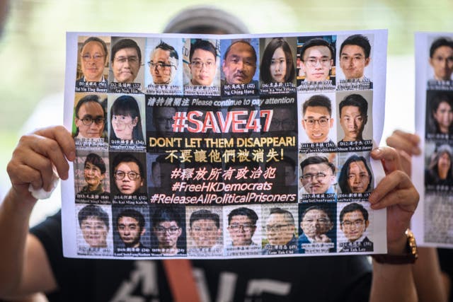 <p>File. A supporter holds a poster showing some of the 47 pro-democracy activists on trial at the West Kowloon Court in Hong Kong on 8 July 2021</p>