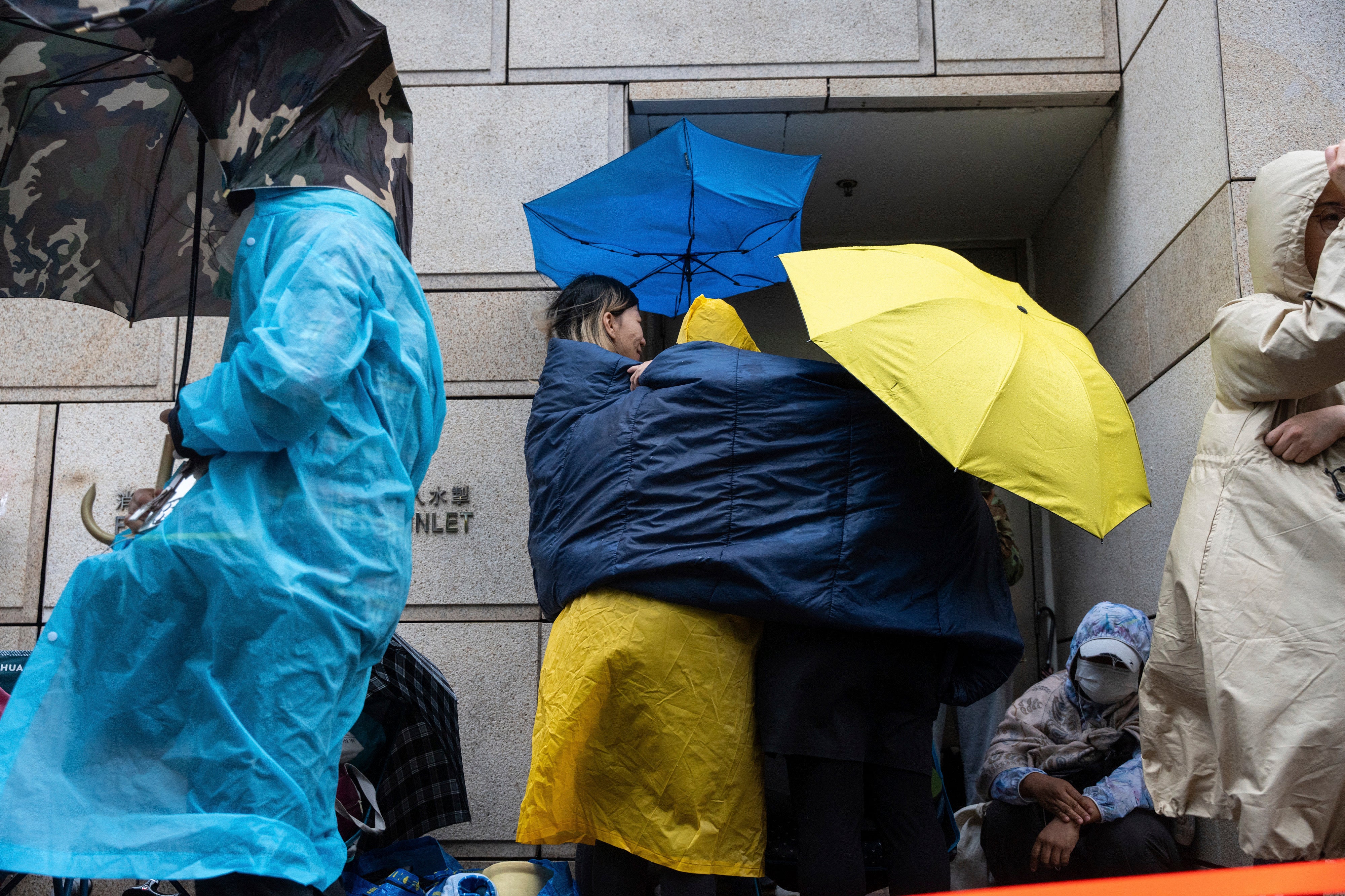 People wait outside the Hong Kong High Court ahead of sentencing in the national security case on 19 November 2024