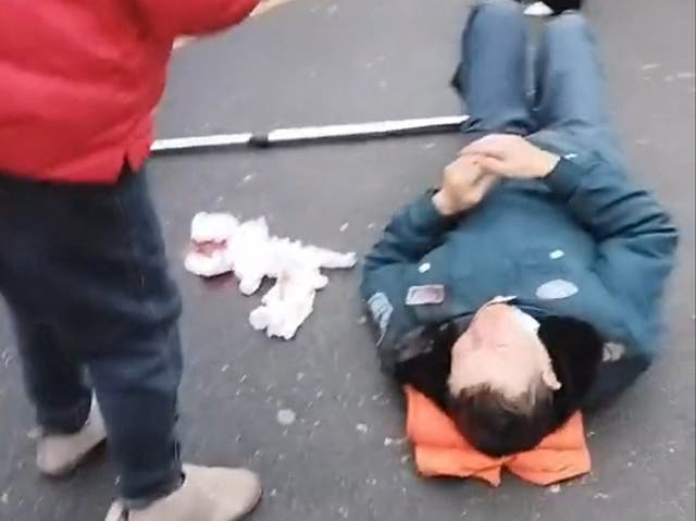 <p>A person lies on the ground following a vehicle collision outside a primary school in Changde, Hunan province</p>