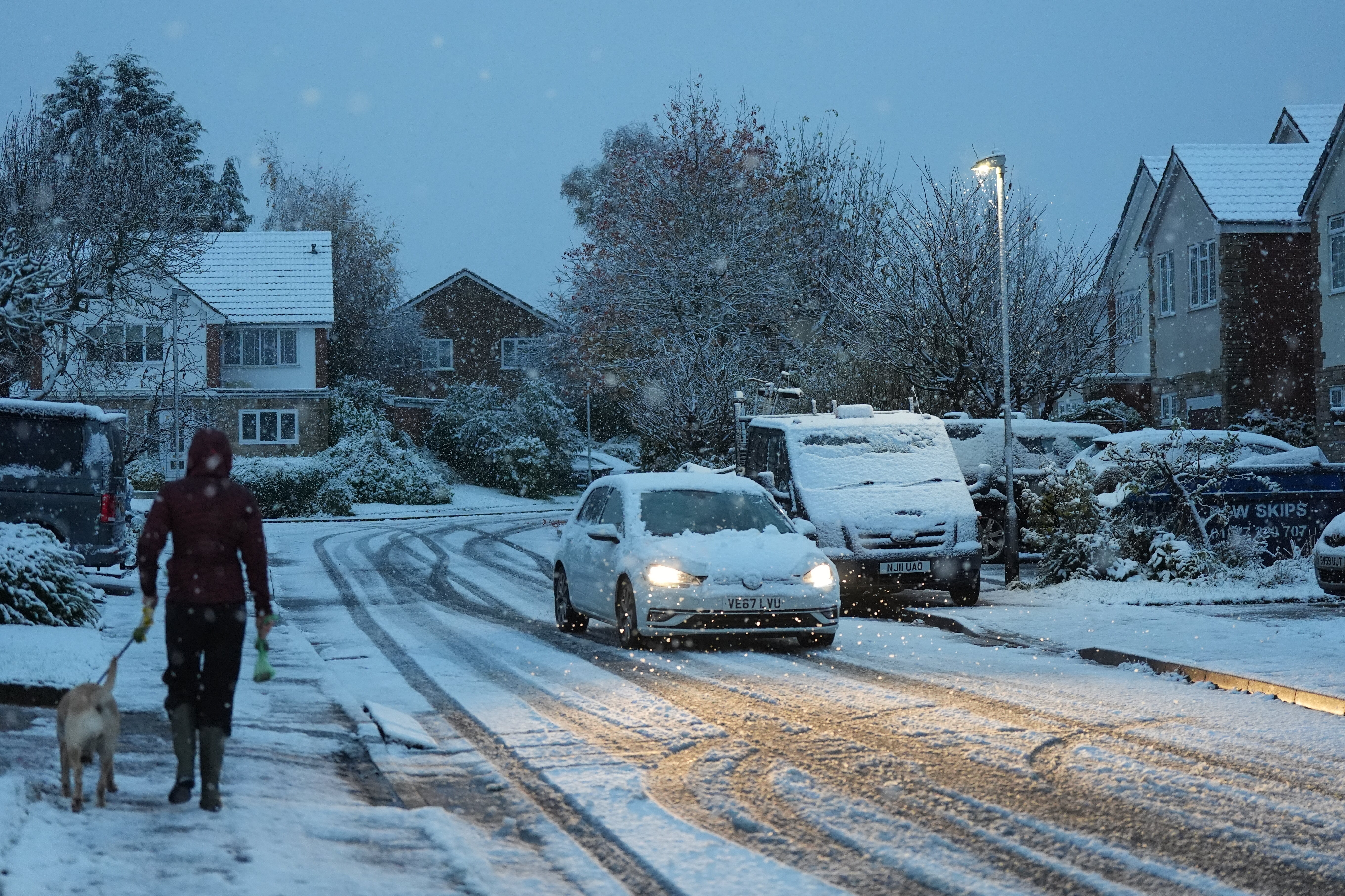 A person walks their dog through snow in Warwick