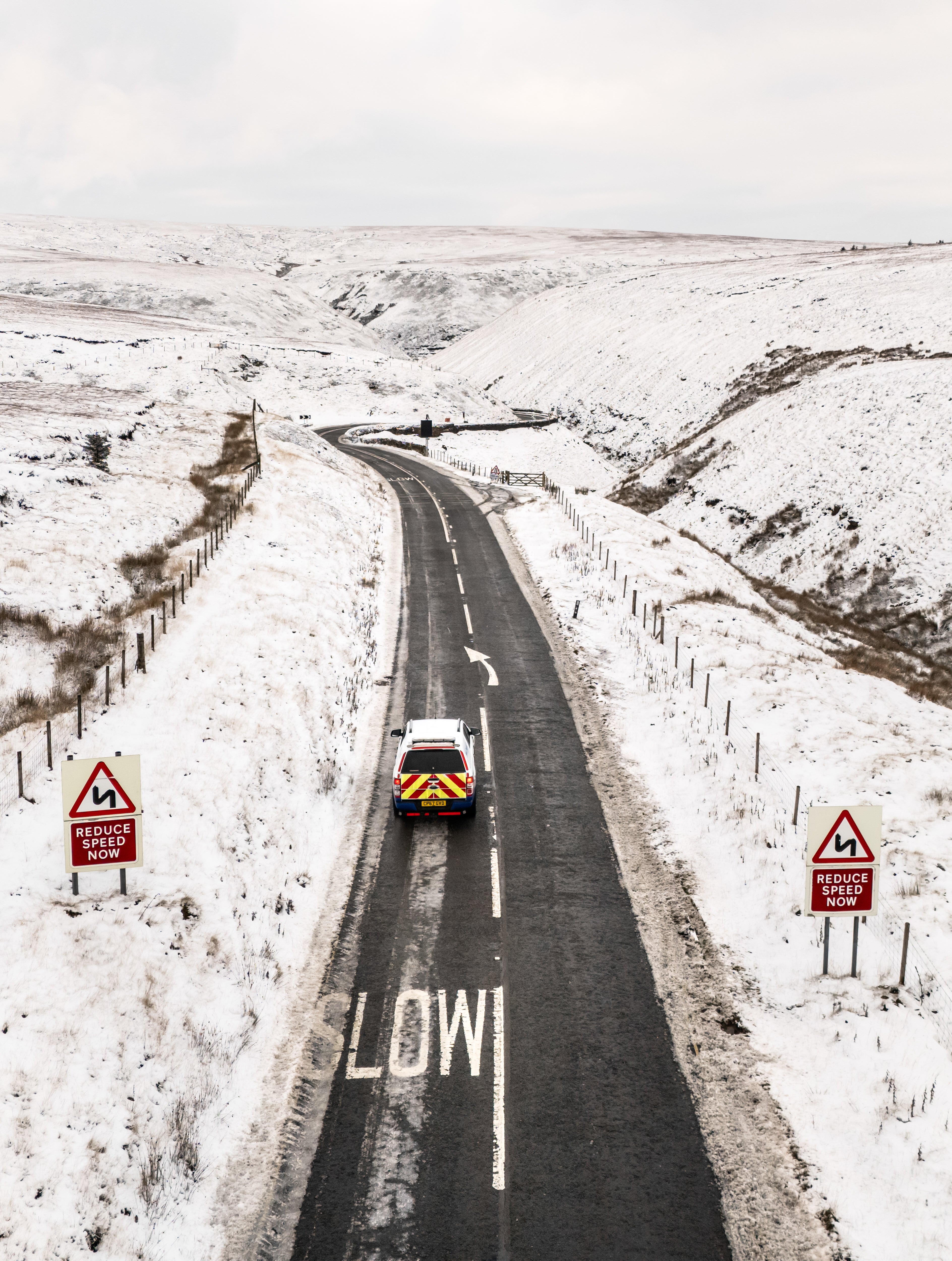 Cars driving down the snow-covered Snake Pass