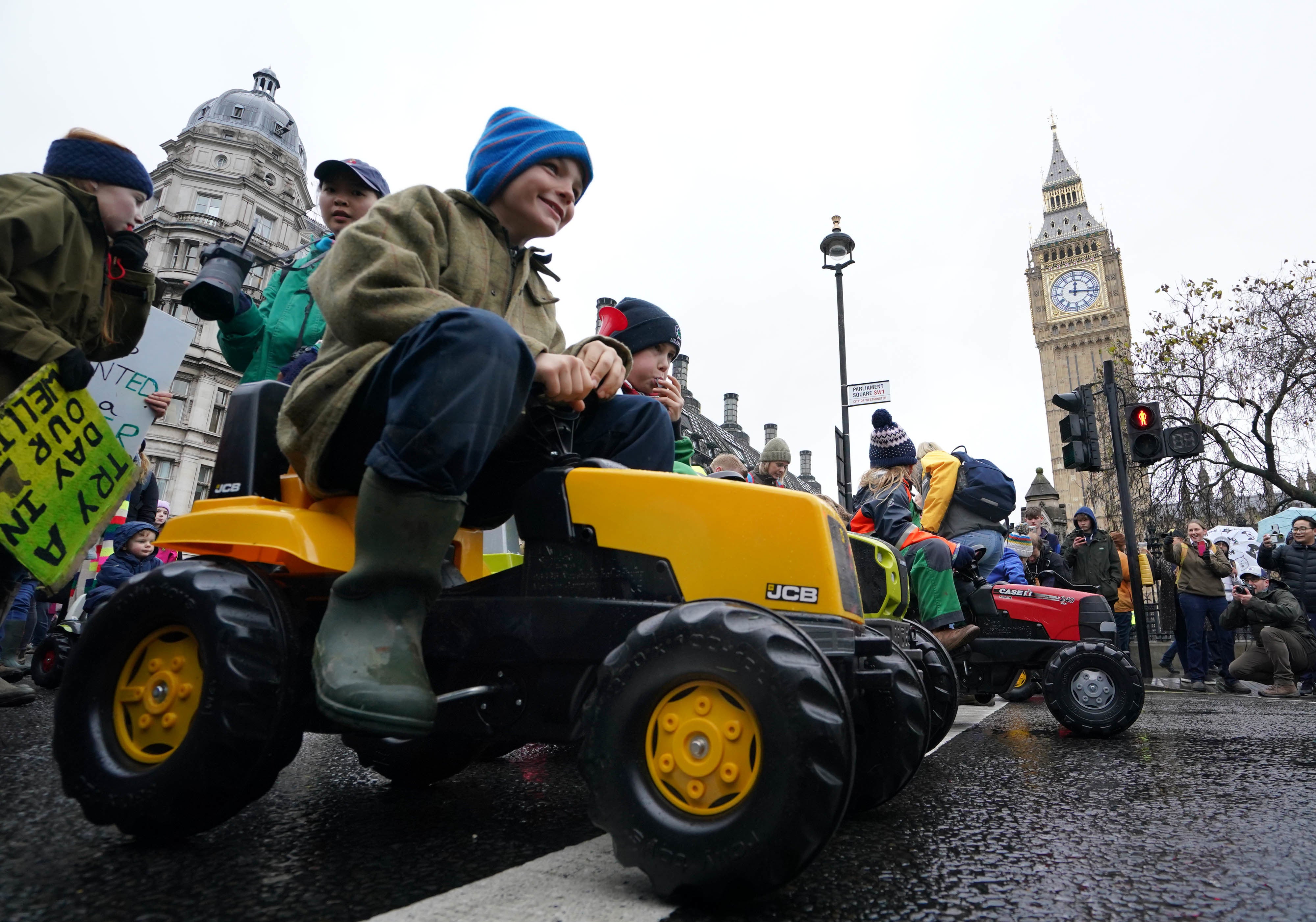 Children ride on toy tractors as part of the farmers’ protest in central London (Gareth Fuller/PA)