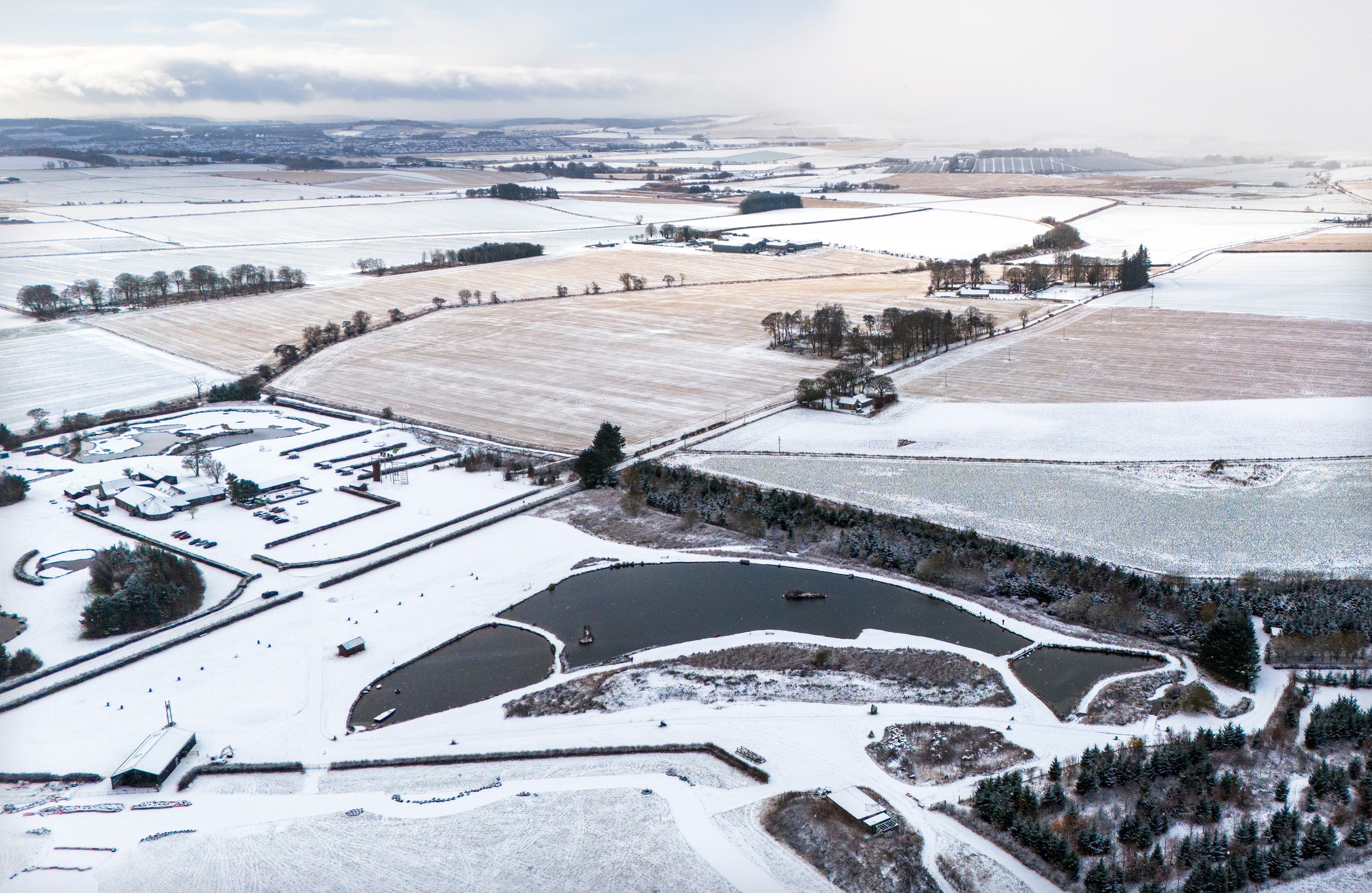 The man-made fish-shaped Muckle Troot Loch near Inverurie, Aberdeenshire, is surrounded by snow and ice