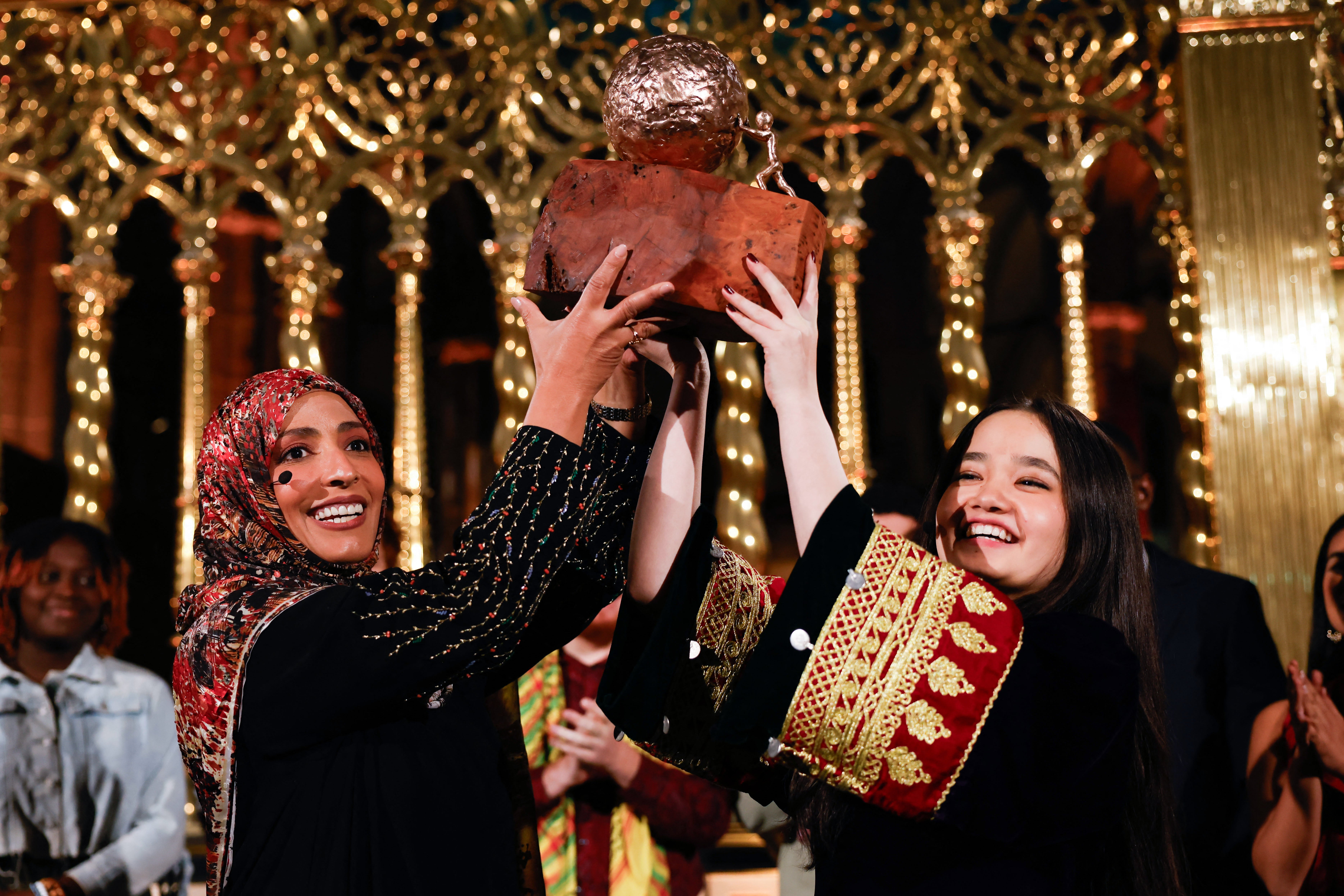 Nila lifts her prize alongside Yemeni Nobel laureate Tawakkol Karman