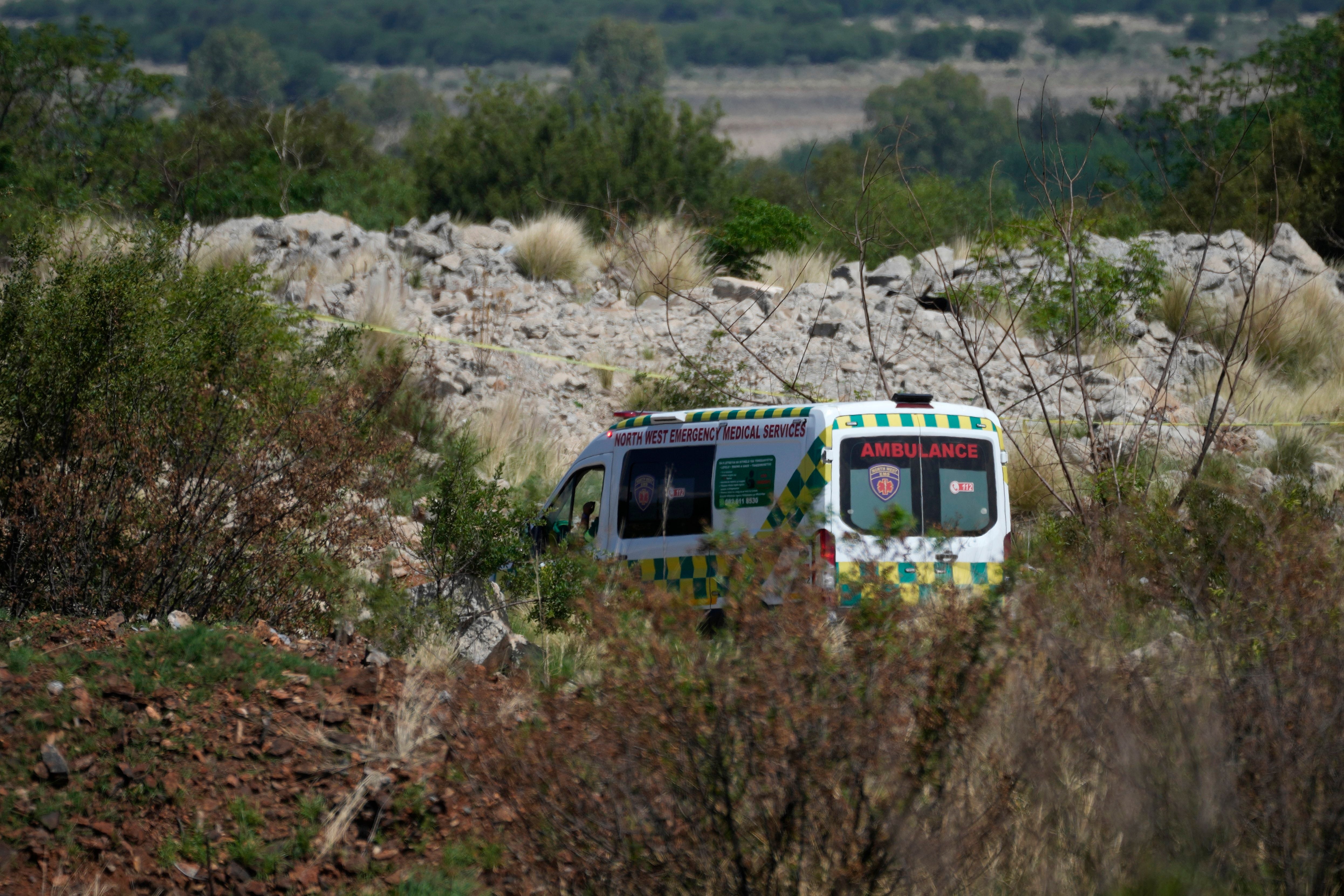 An ambulance parks near by the opening of a reformed gold mineshaft where illegal miners are trapped in Stilfontein