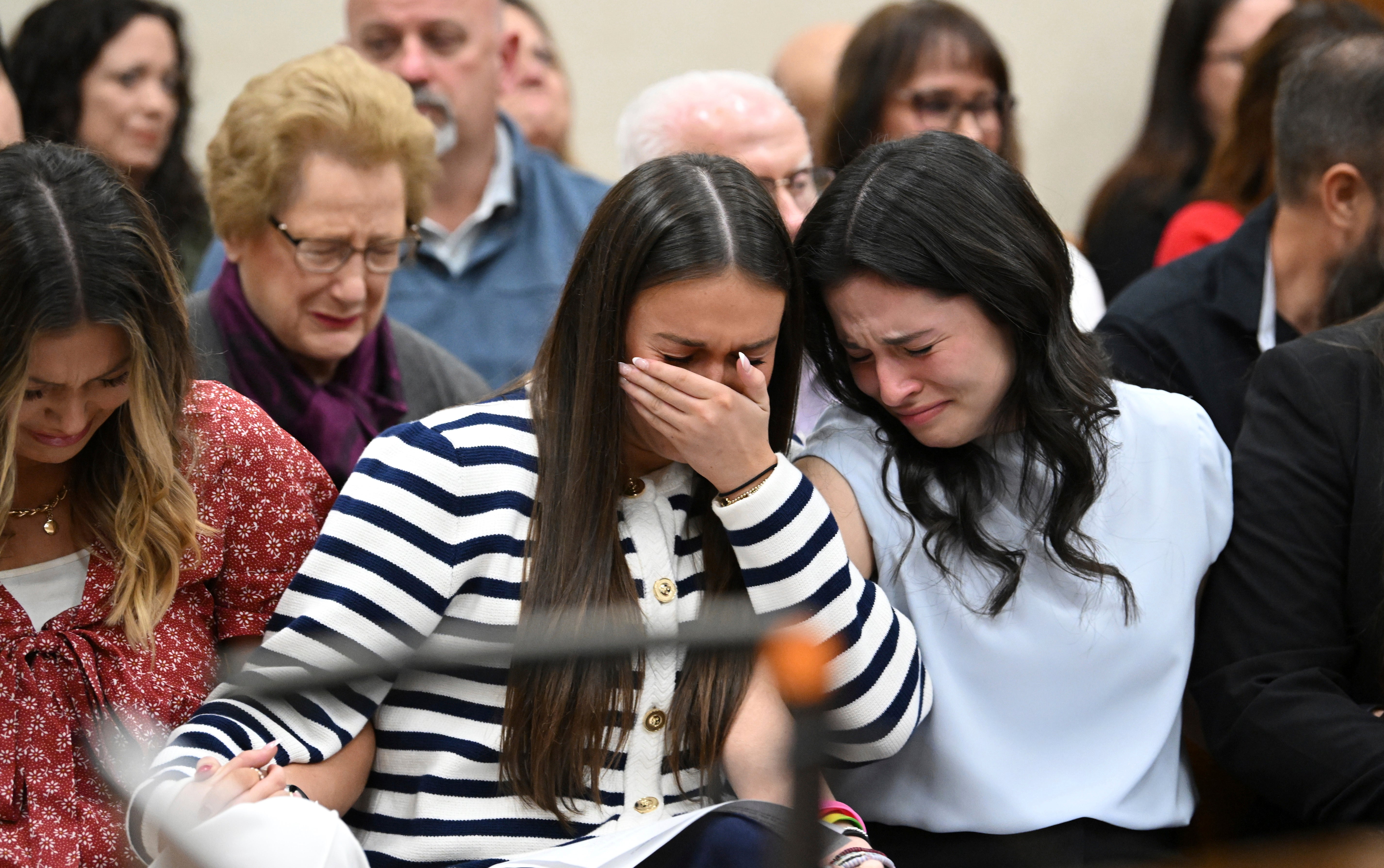 Connolly Huth and Sofia Magana, left and right, roommates of Laken Riley, and Lauren Phillips, sister of Laken Riley, centre, react as the verdict is announced.