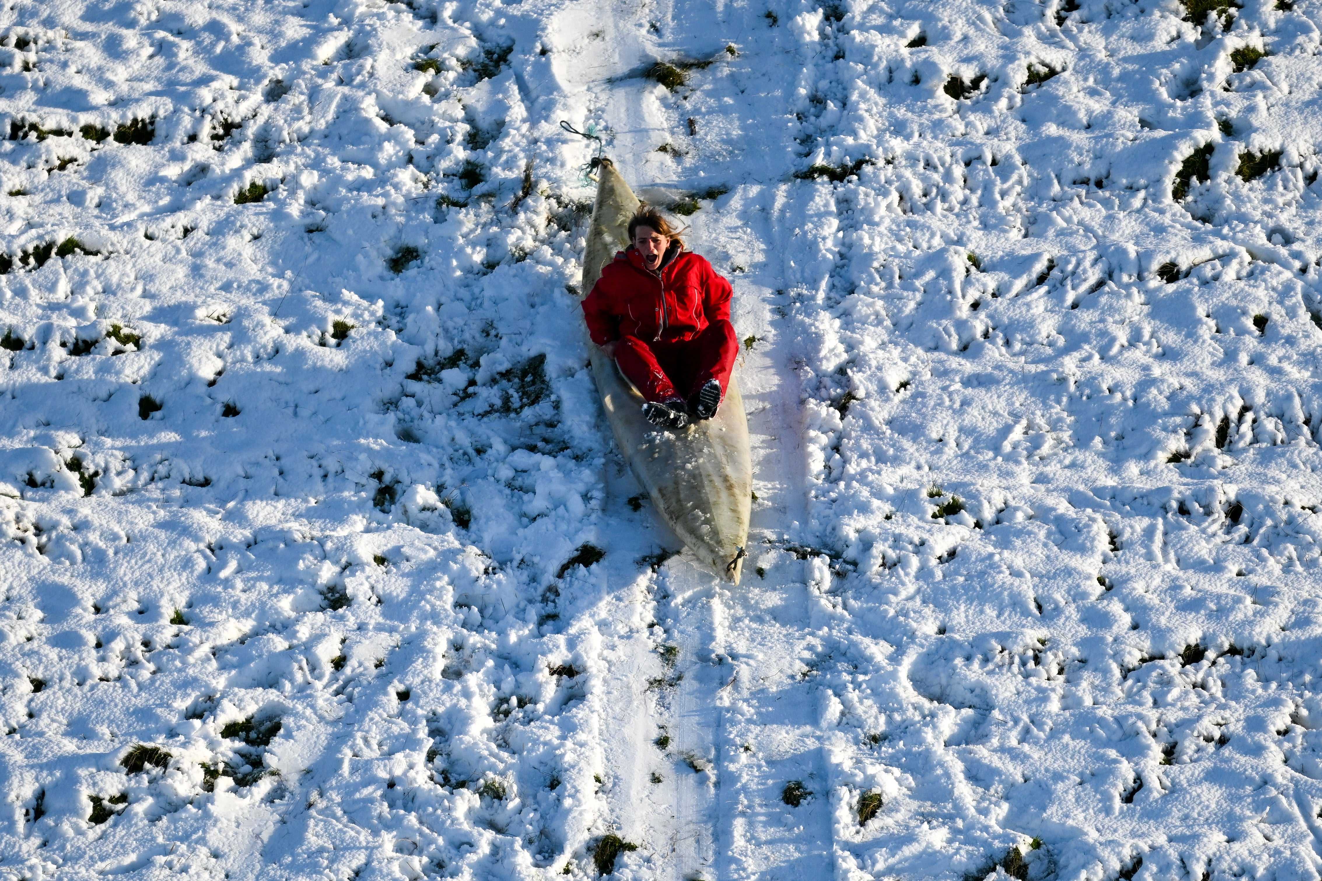 A person sledges down a hill in a canoe near Dorchester