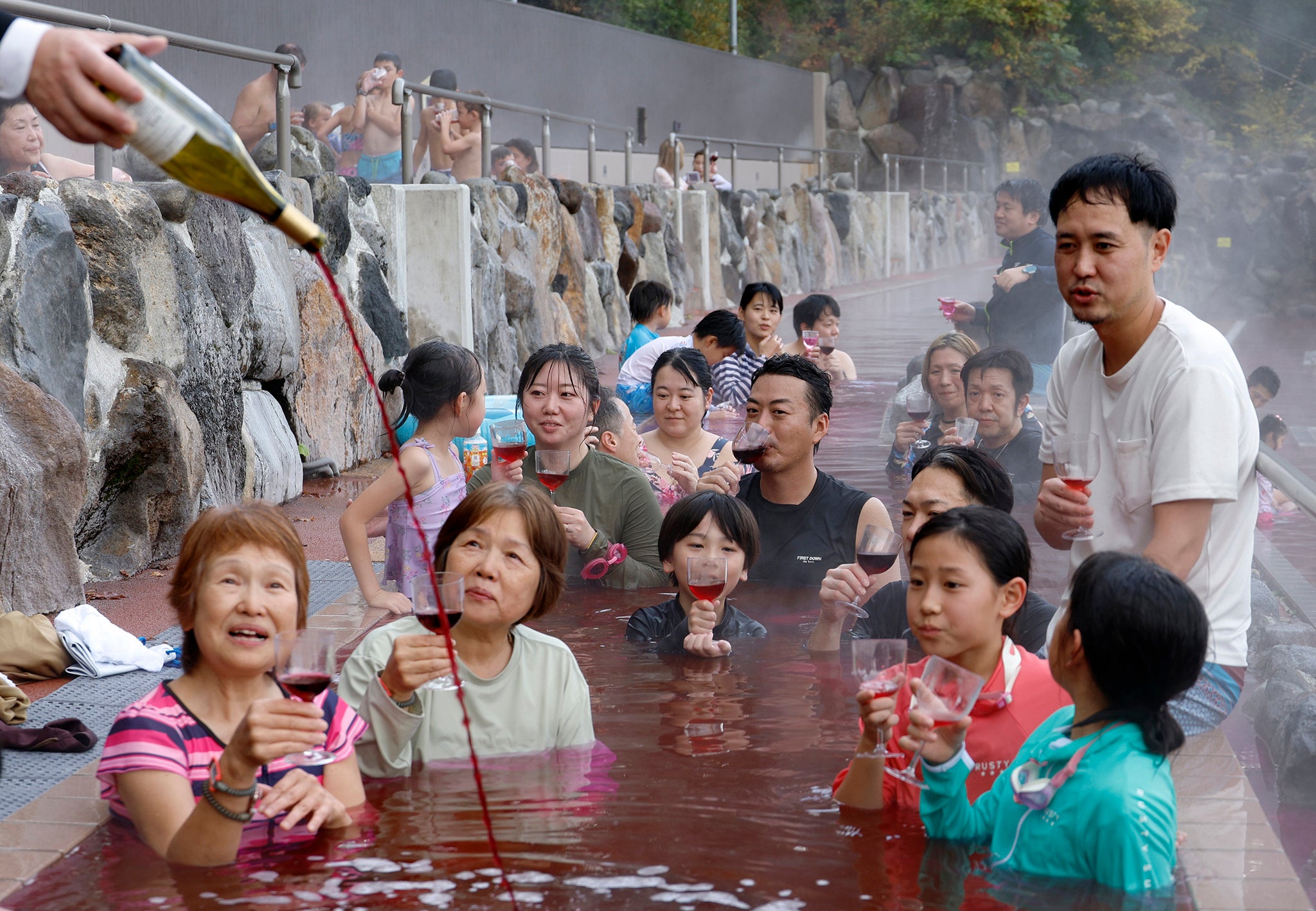 A sommelier pours 2024 Beaujolais Nouveau into a bath on the day of the Beaujolais Nouveau official release in Hakone, Japan
