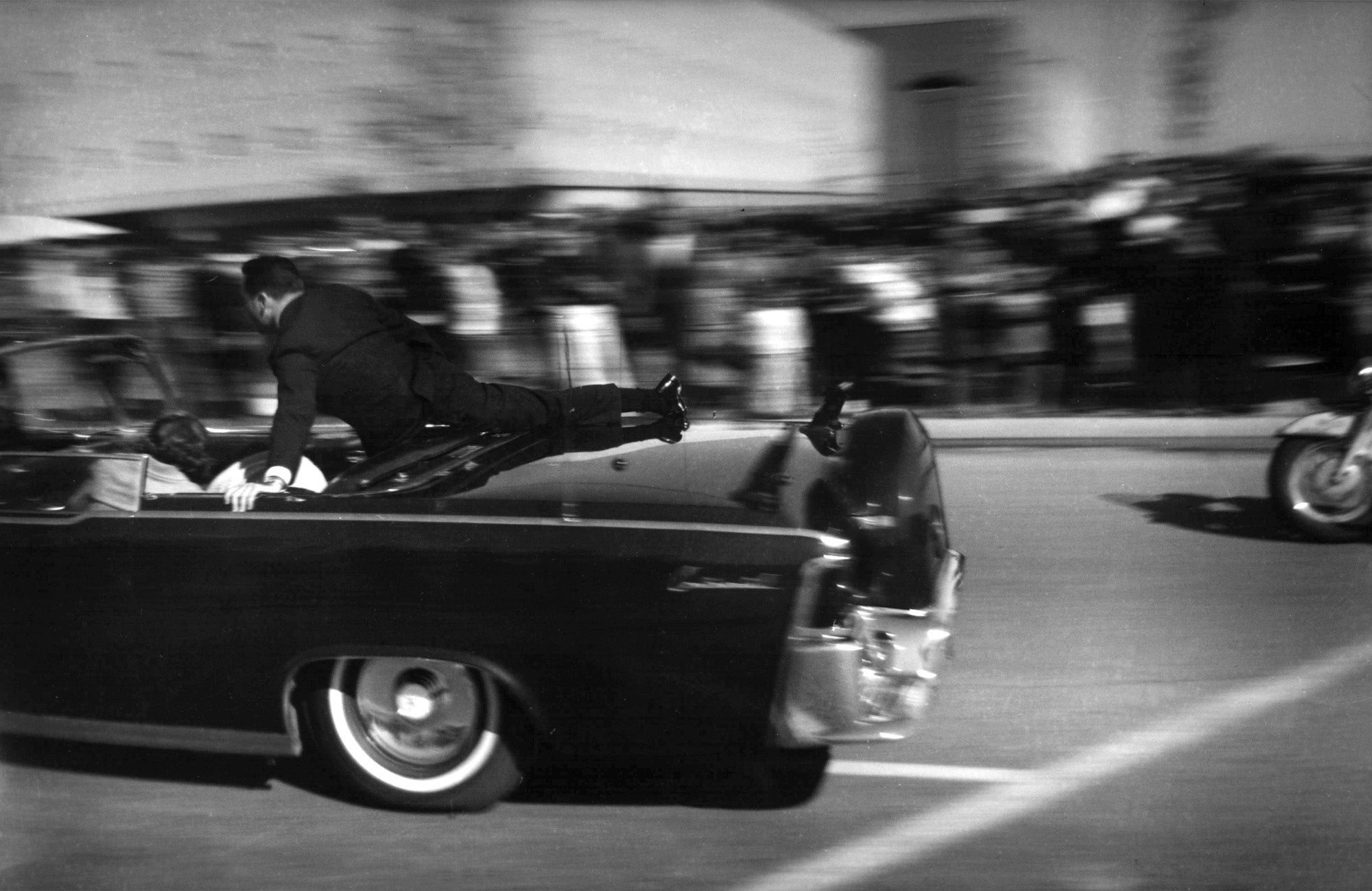 The limousine carrying mortally wounded President John F. Kennedy races toward the hospital seconds after he was shot