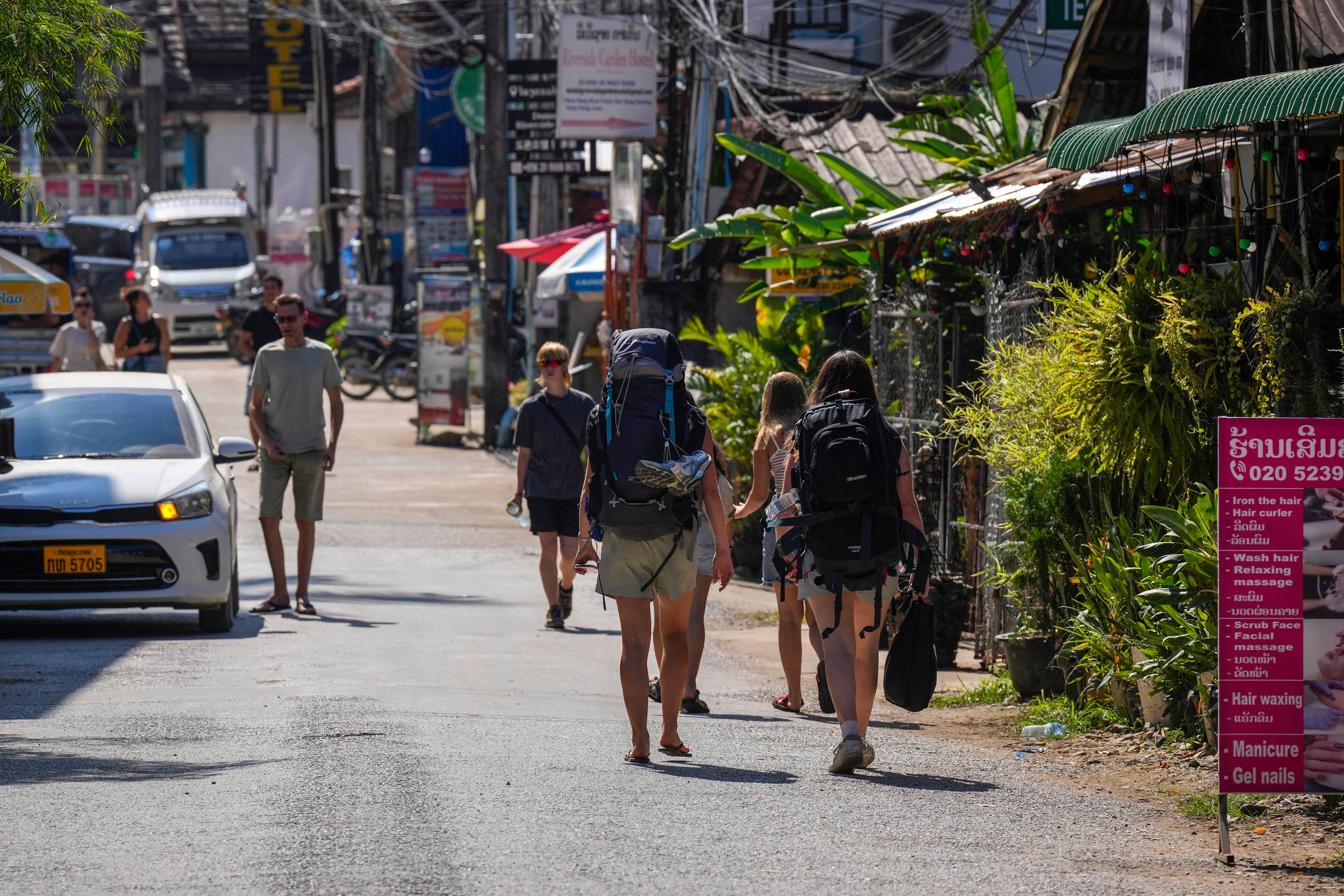 Backpackers roam the streets of Vang Vieng on Friday