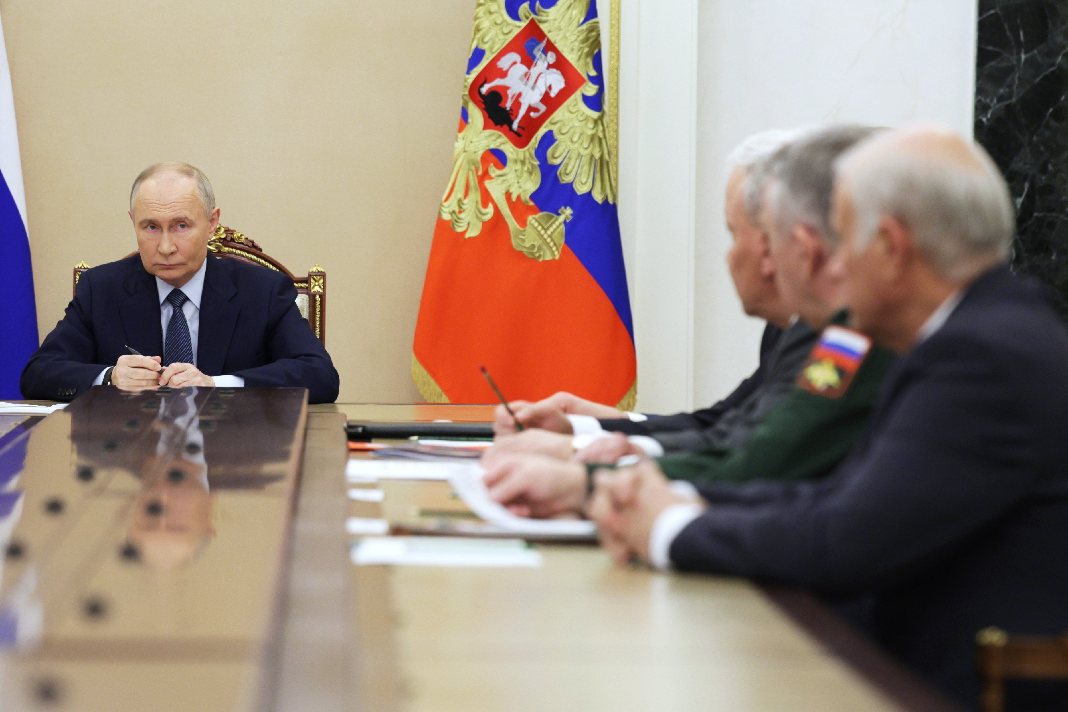 Russian President Vladimir Putin (L) holds a meeting with the defence officials in Moscow