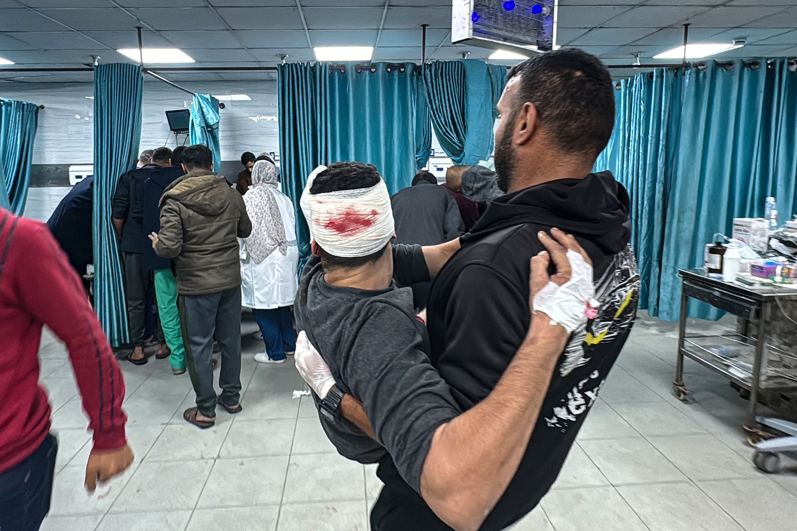 An injured Palestinian man is transported to the emergency ward of the Kamal Adwan Hospital