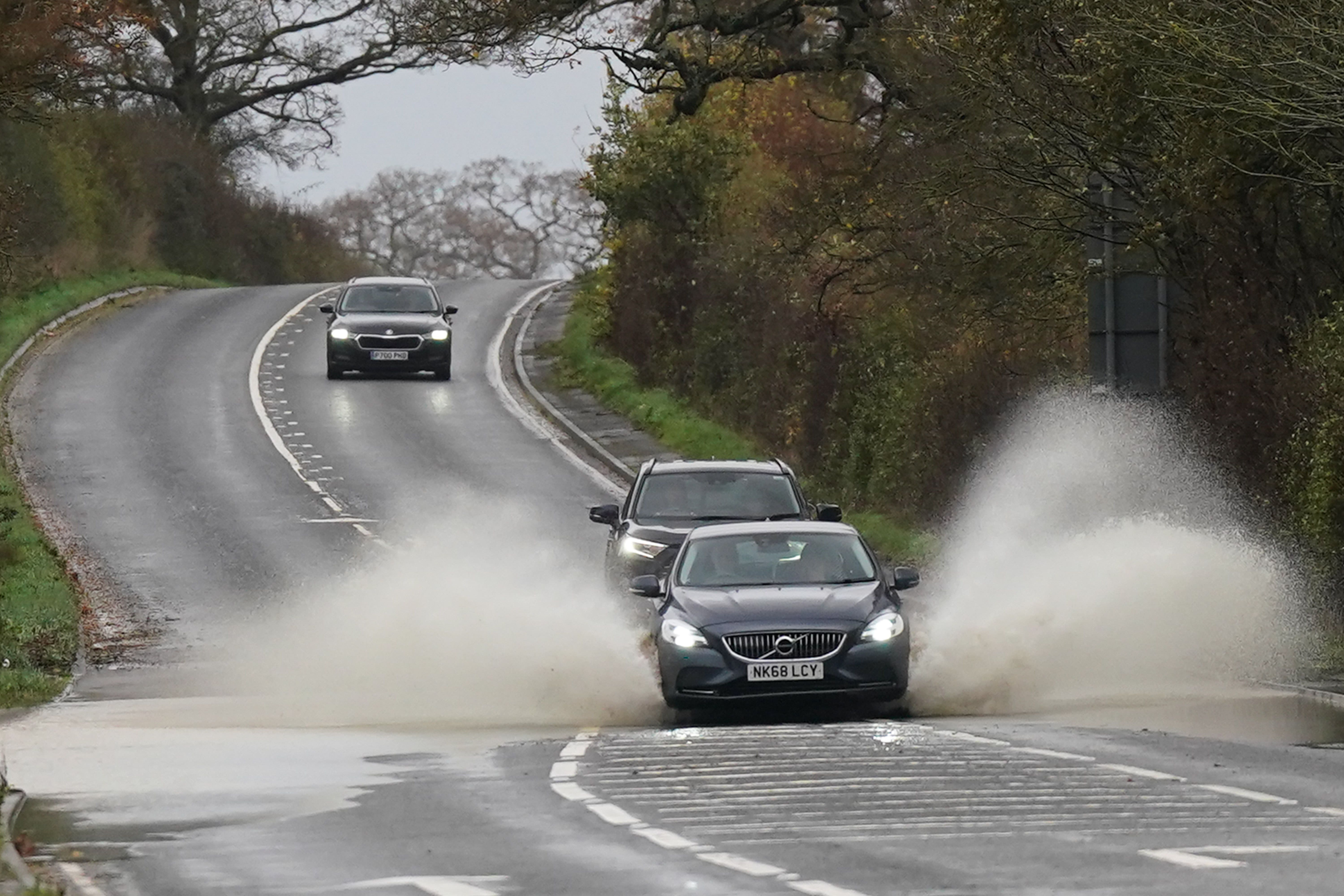 A vehicle is driven through floodwater after heavy rain in Shipston-on-Sour in Warwickshire (Jacob King/PA)