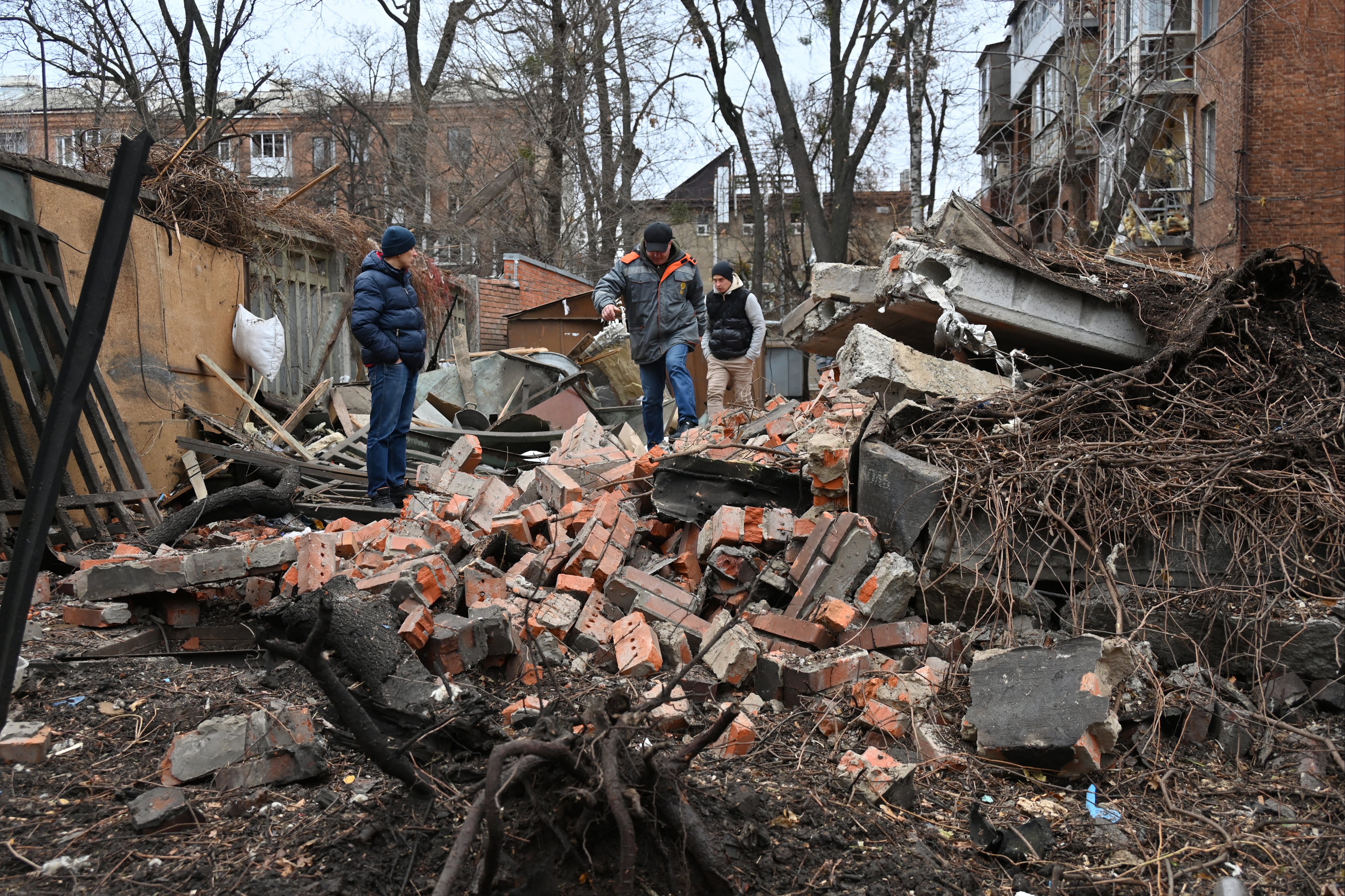 Local residents walk among debris in the courtyard of a residential building following a missile attack in Kharkiv