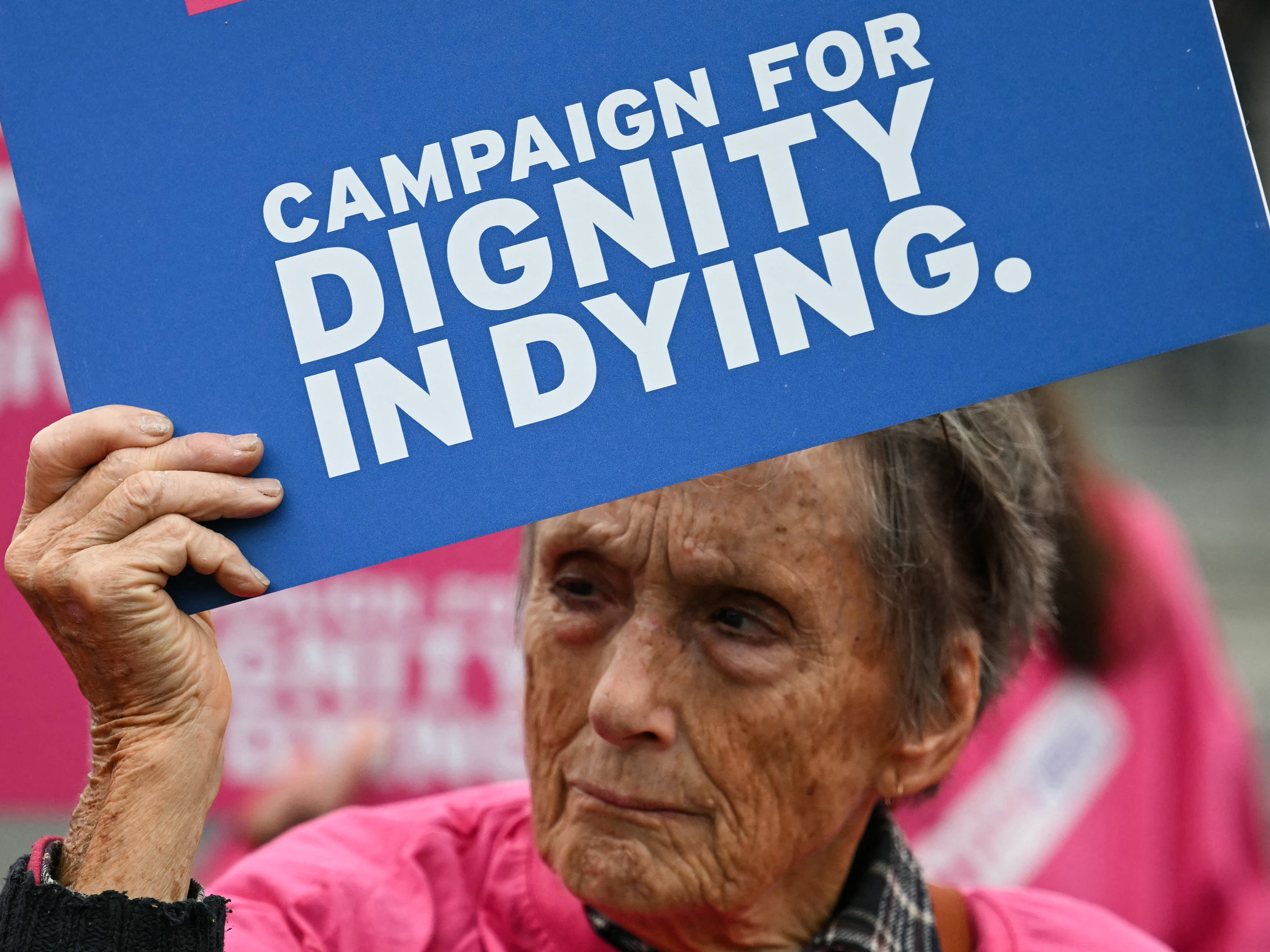 A campaigner from "Dignity in Dying" holds a placard during a demonstration outside Westminster