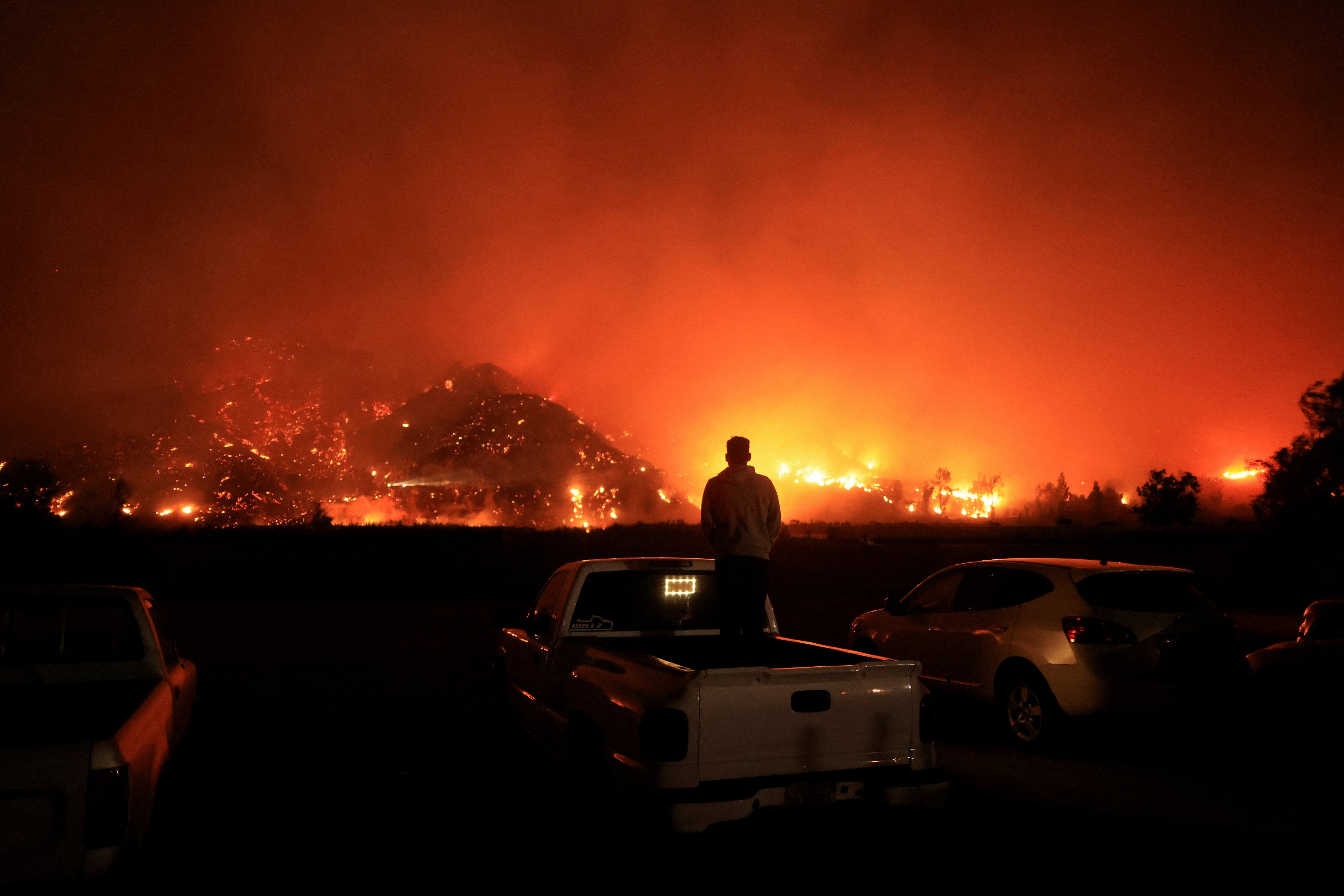 A person looks on as smoke and flames billow from the Mountain Fire in Santa Paula, California, earlier this month. Wildfires, which spark year-round in California’s dry climate, bring the risk of exposure to smoke for those not immediately impacted by the blazes. While doctors knew about its threats to heart and respiratory health, research into ties to dementia is fairly recent