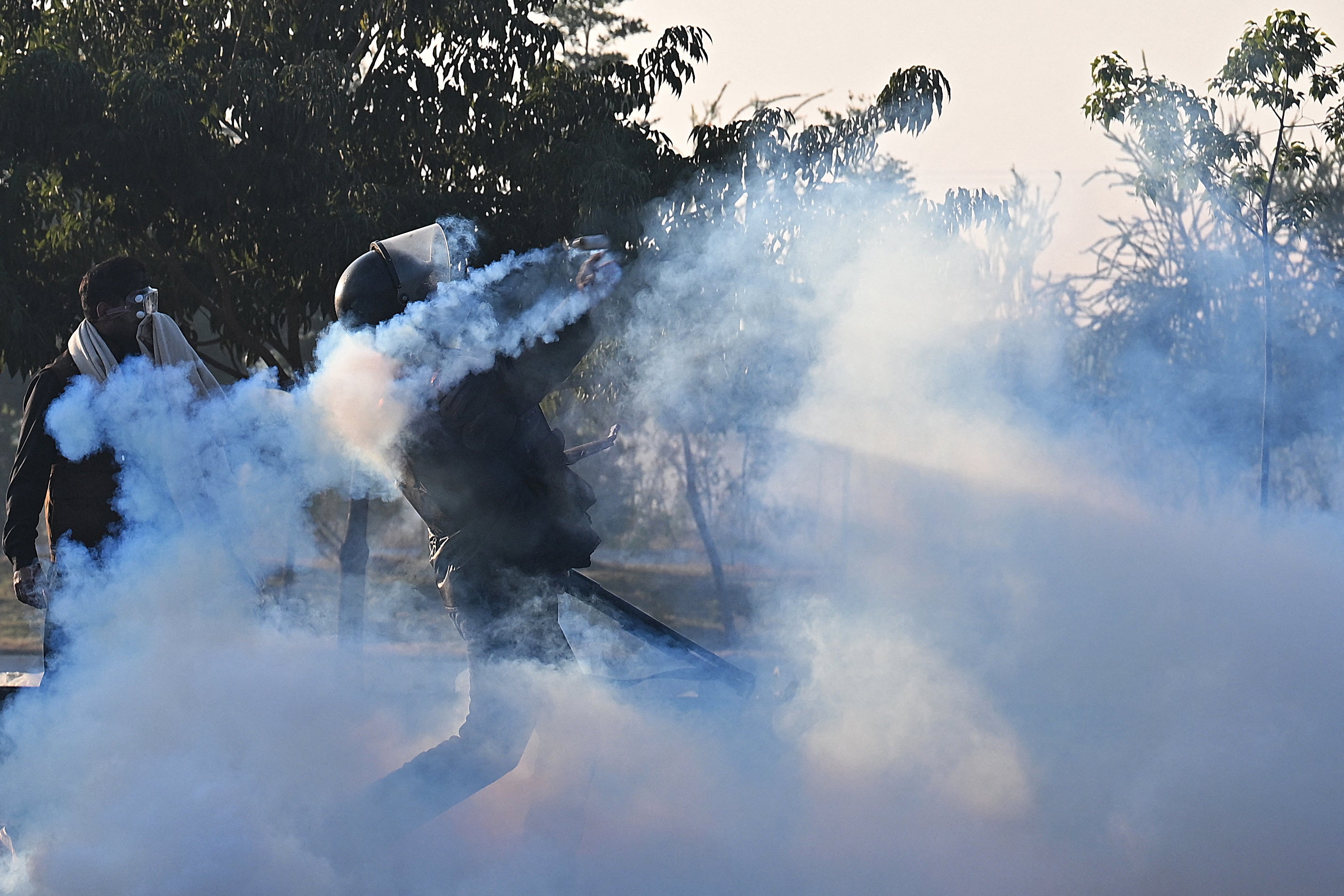 Policemen fire tear gas shells to disperse supporters of Pakistan Tehreek-e-Insaf (PTI) party during a protest