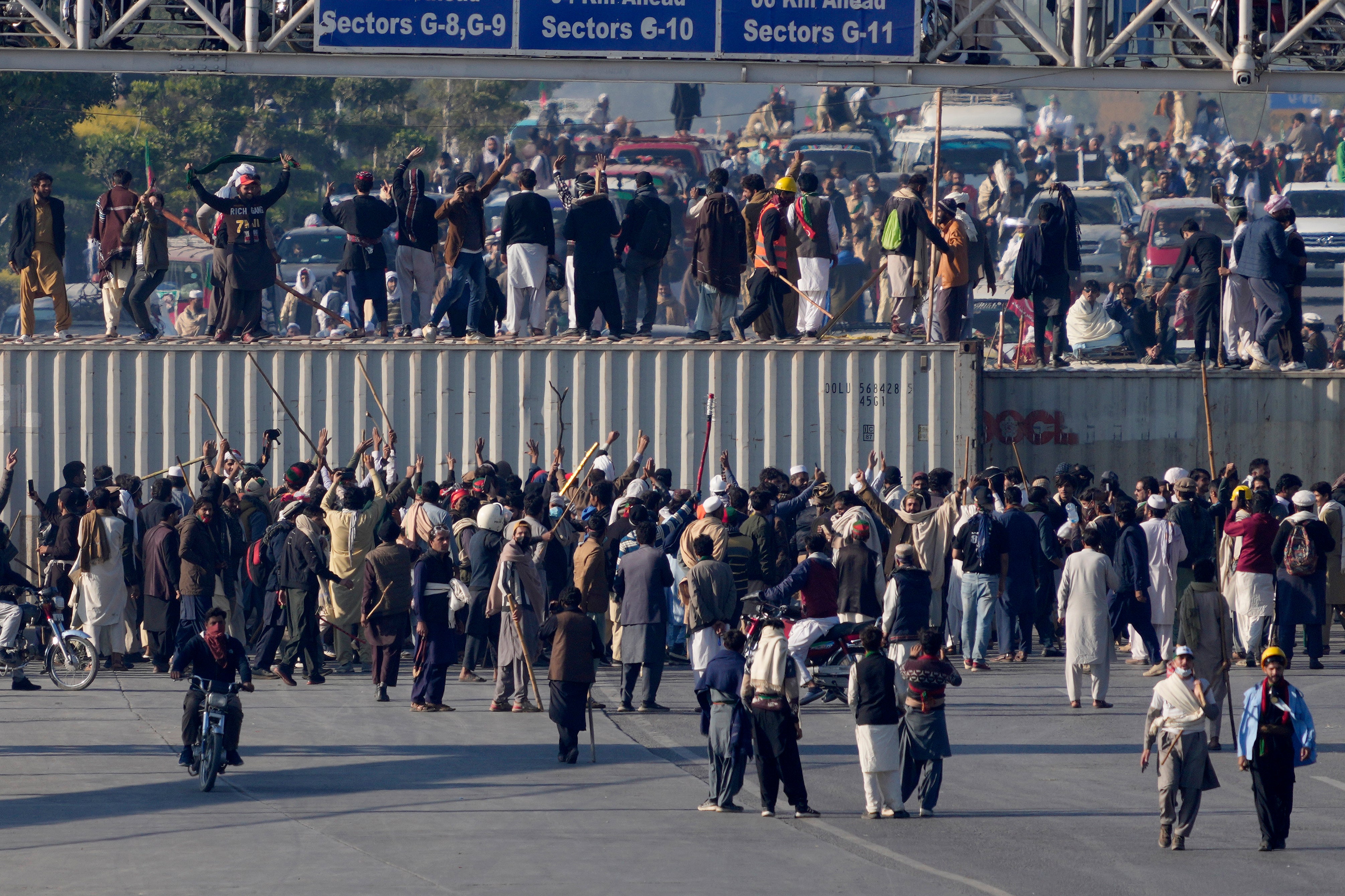 Supporters of imprisoned former premier Imran Khan's Pakistan Tehreek-e-Insaf party, gather to remove shipping containers to clear way for their rally