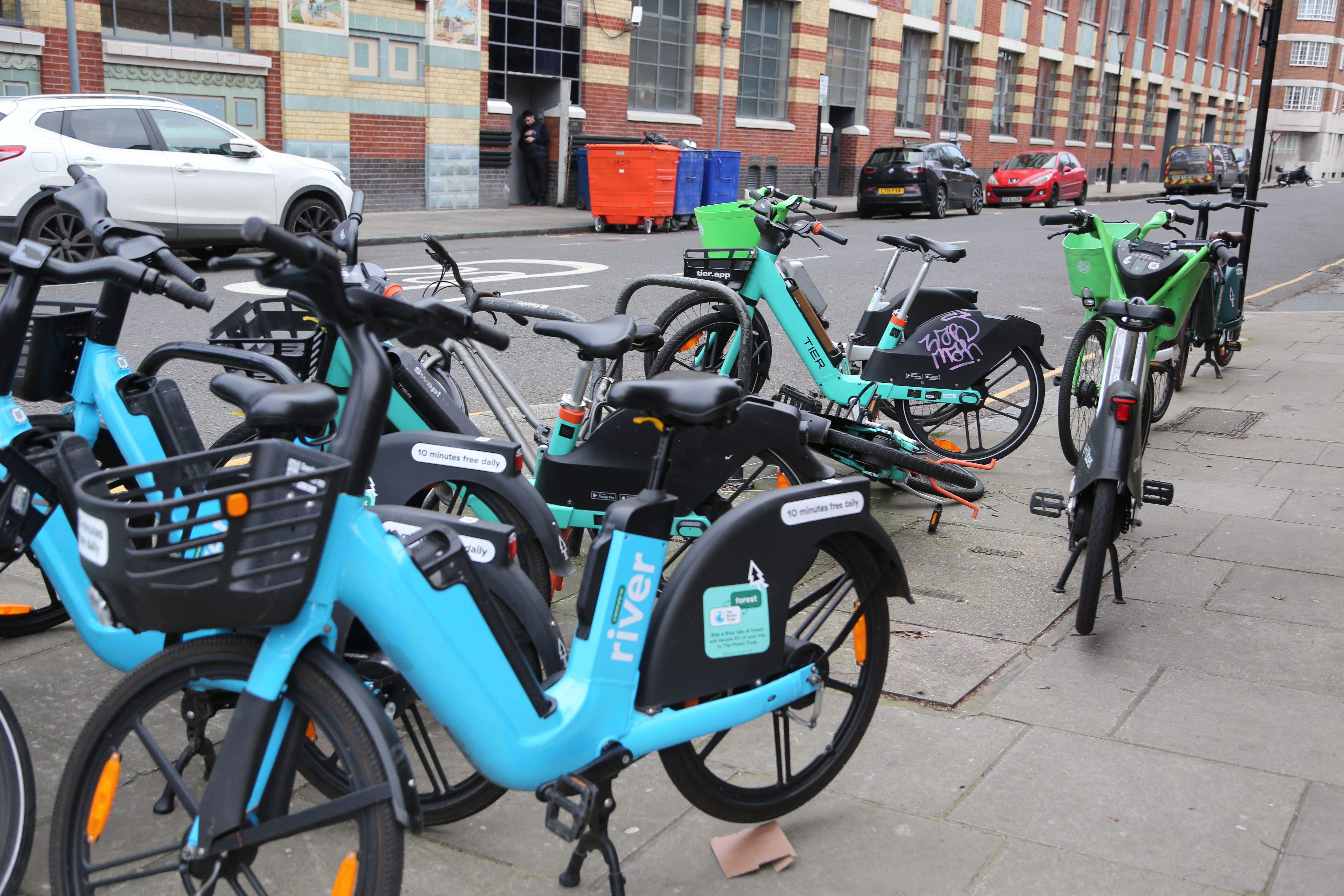 Tier, Lime and River e-bikes on a pavement in Chelsea, west London