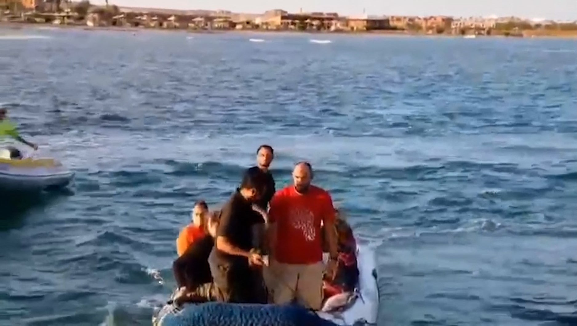 Rescue workers help tourists and crew members after boat escape