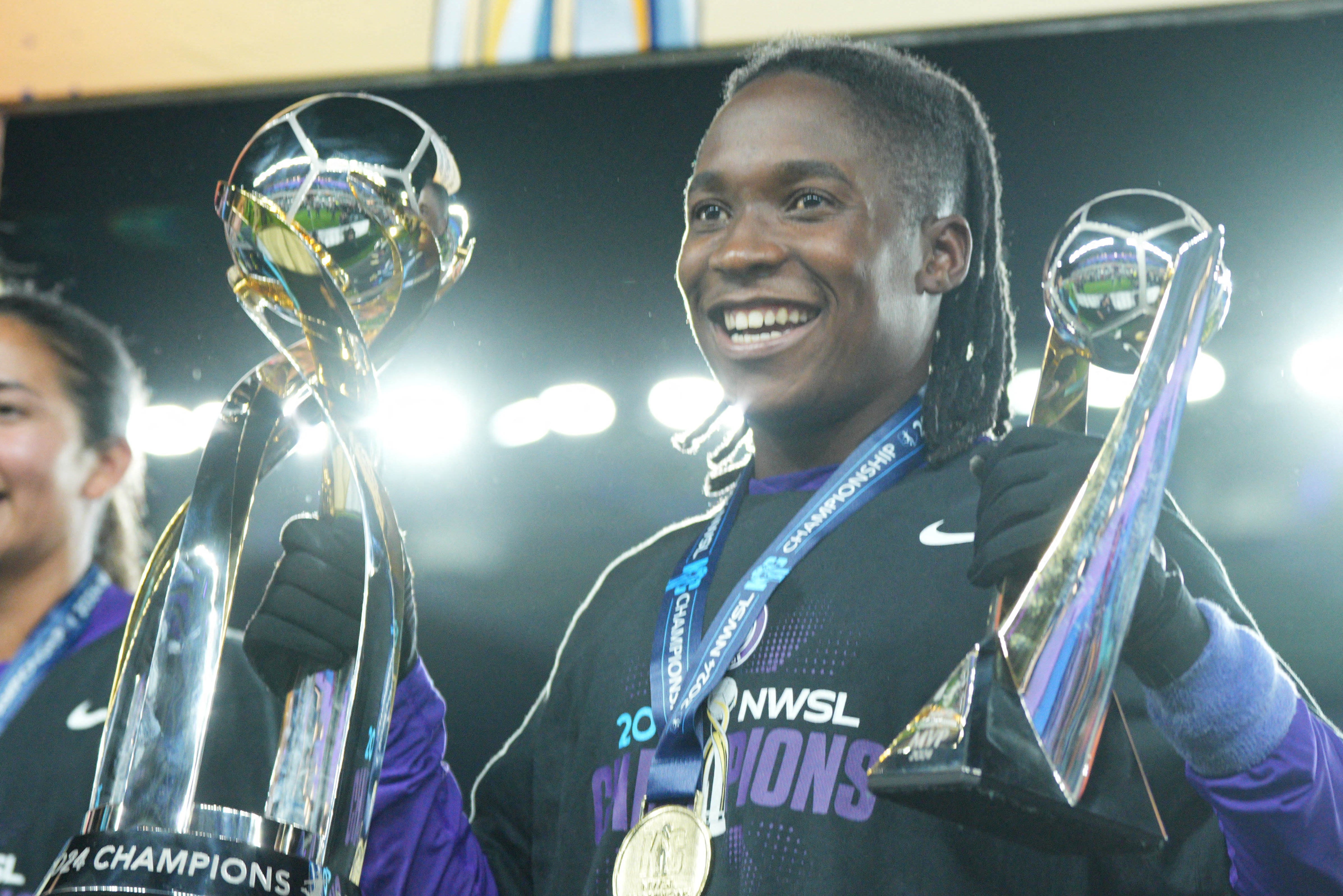 Barbra Banda celebrates with the NWSL championship and MVP trophies