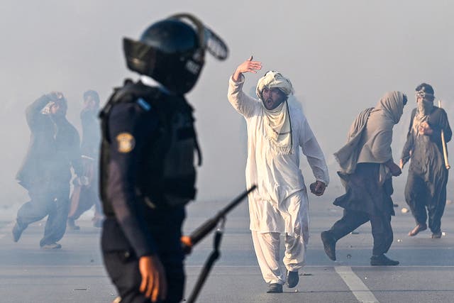 <p>A supporter of Pakistan Tehreek-e-Insaf (PTI) party gestures after tear gas was fired by the police to disperse the crowd during a protest to demand the release of former prime minister Imran Khan in Islamabad on 26 November 2024 </p>