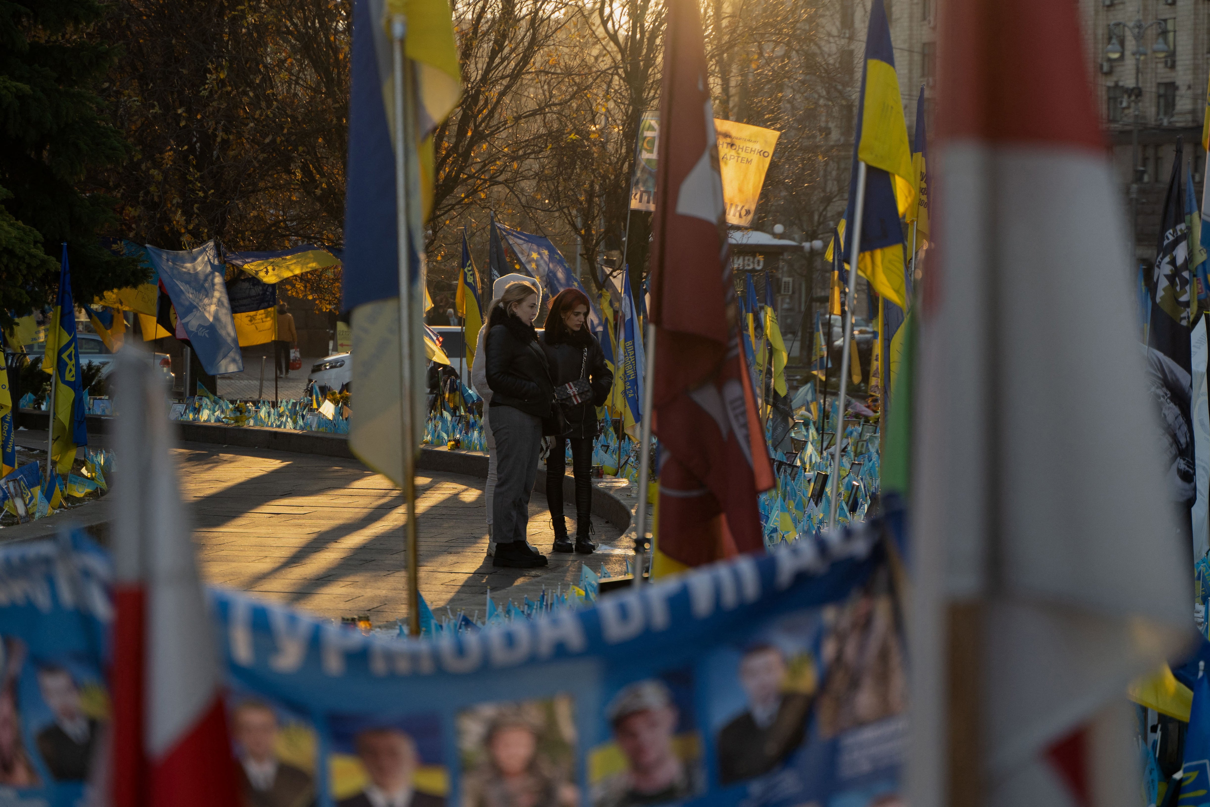 People visit the makeshift memorial paying tribute to Ukrainian and foreign fighters at the Independence Square in Kyiv