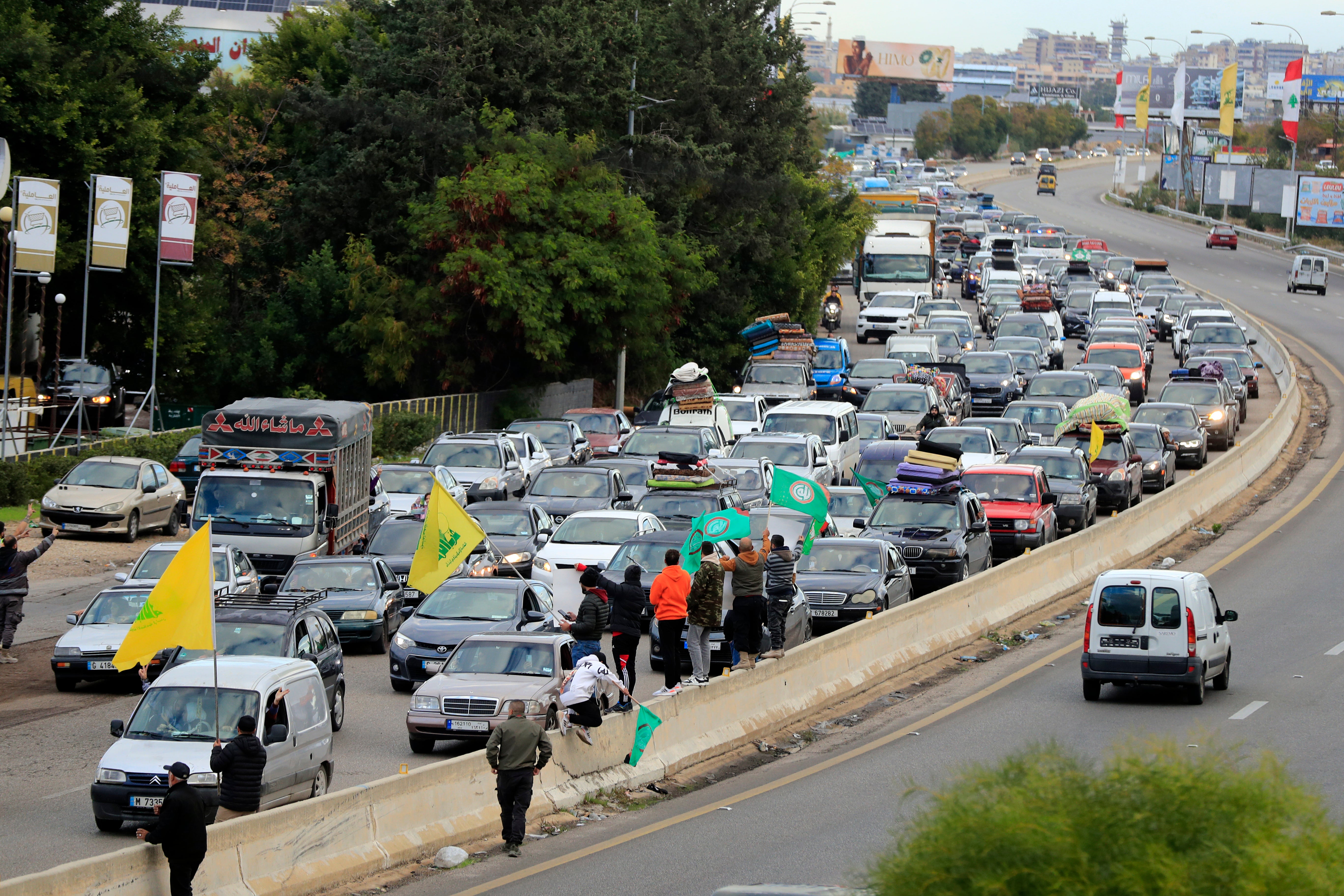 Flags are waved amid banked up traffic as people return home following the ceasefire