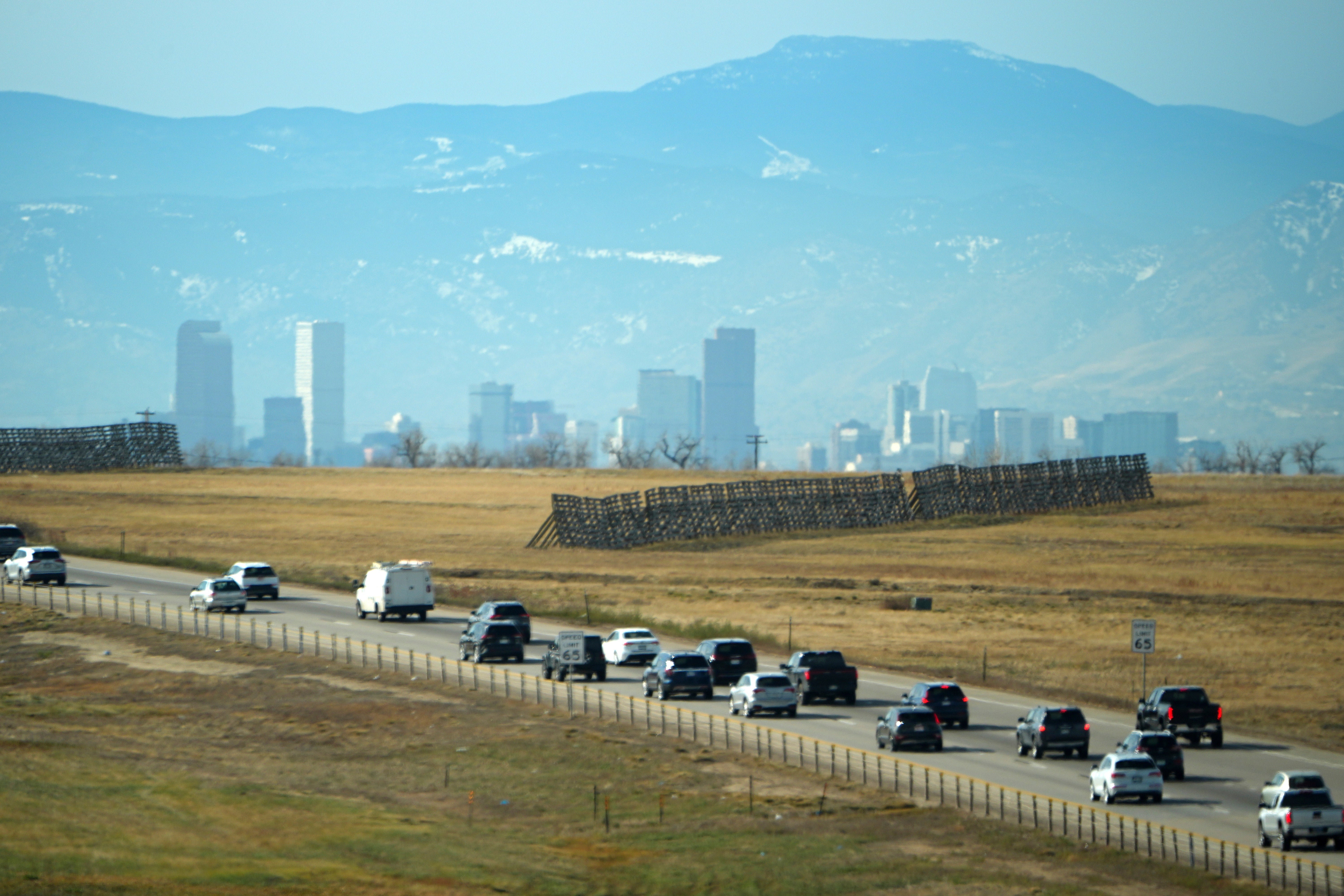 Motorists slowly navigate the southbound lanes of Pena Boulevard to leave Denver International Airport on Tuesday. Snow is expected to end over the Rockies this morning