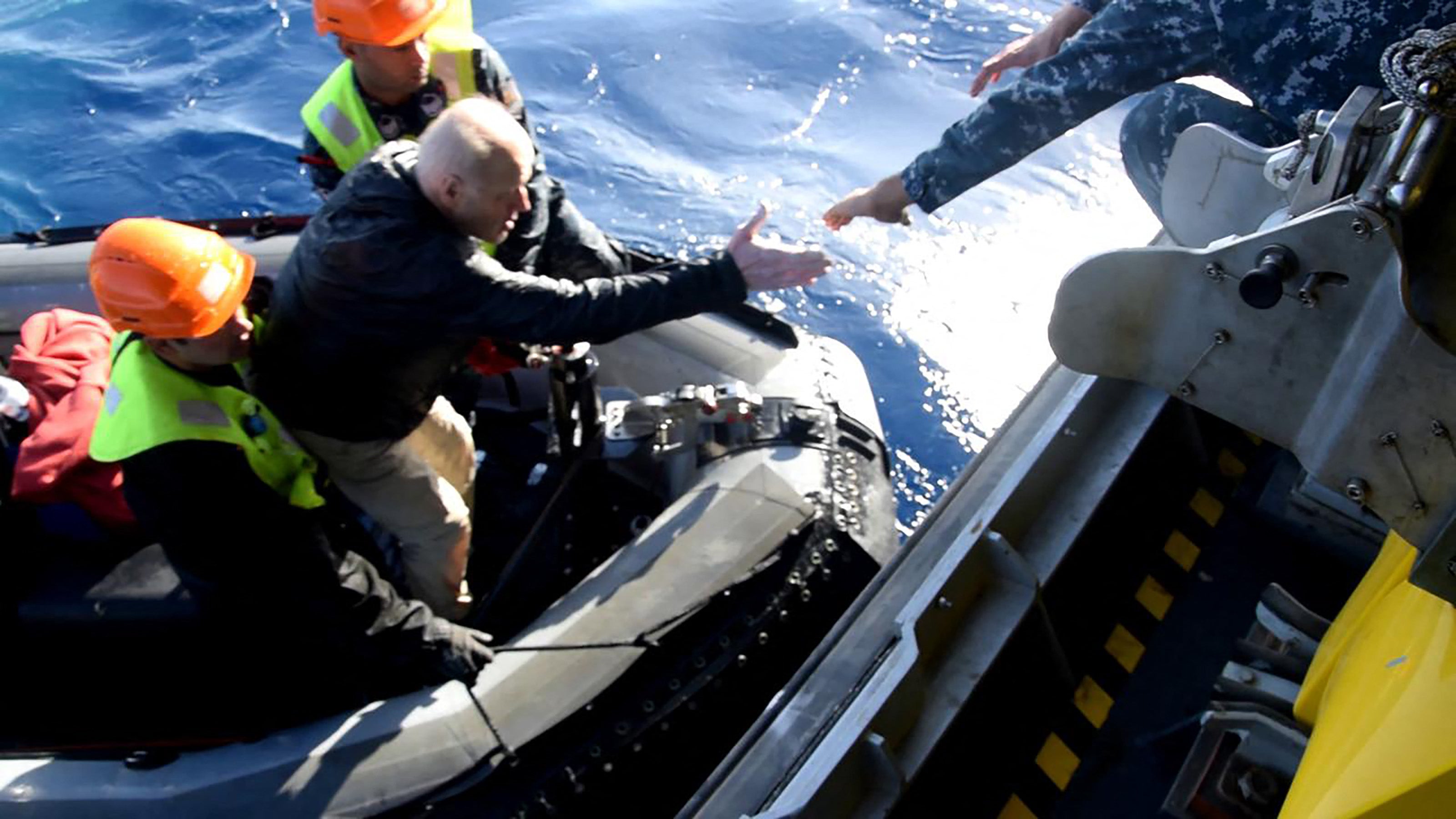 A survivor is helped onboard the rescue vessel