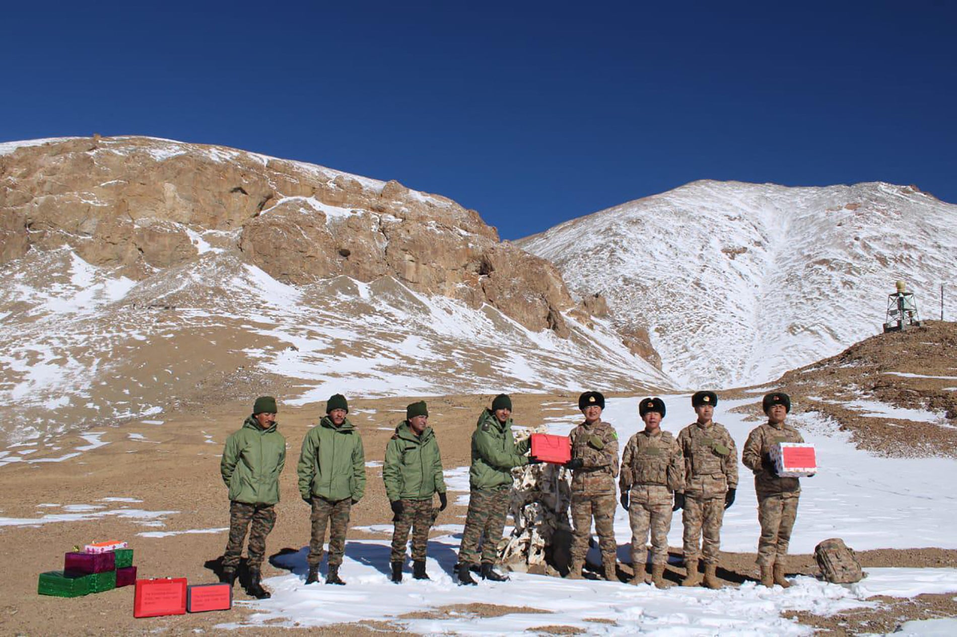 Indian and Chinese soldiers greet each other along the Line of Actual Control near the Karakoram pass in Ladakh on 31 October 2024