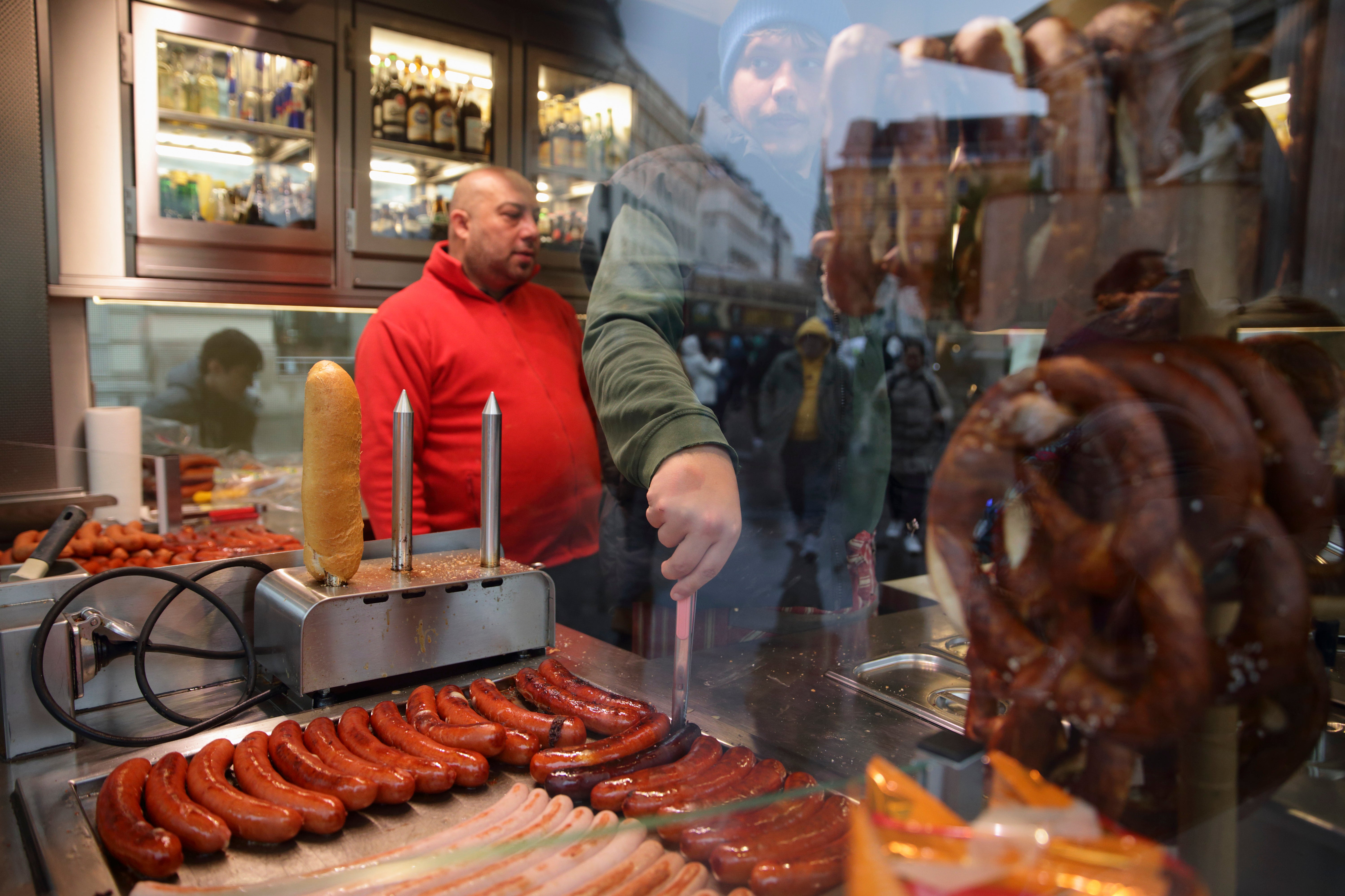 Hot sausages get prepared at a traditional sausage stand (Wuerstelstand)