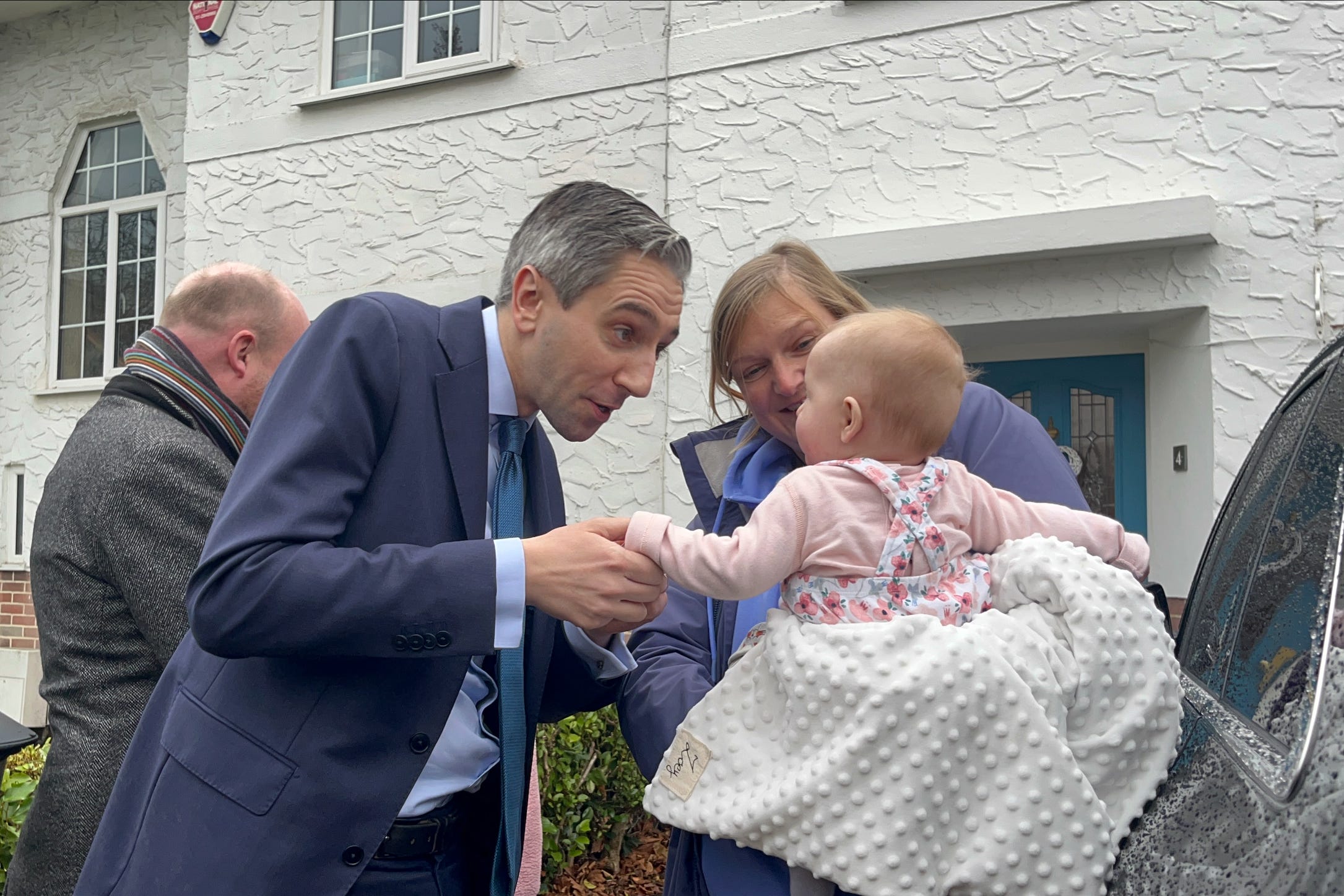 Simon Harris shakes a baby’s hand while canvassing (Claudia Savage/PA)