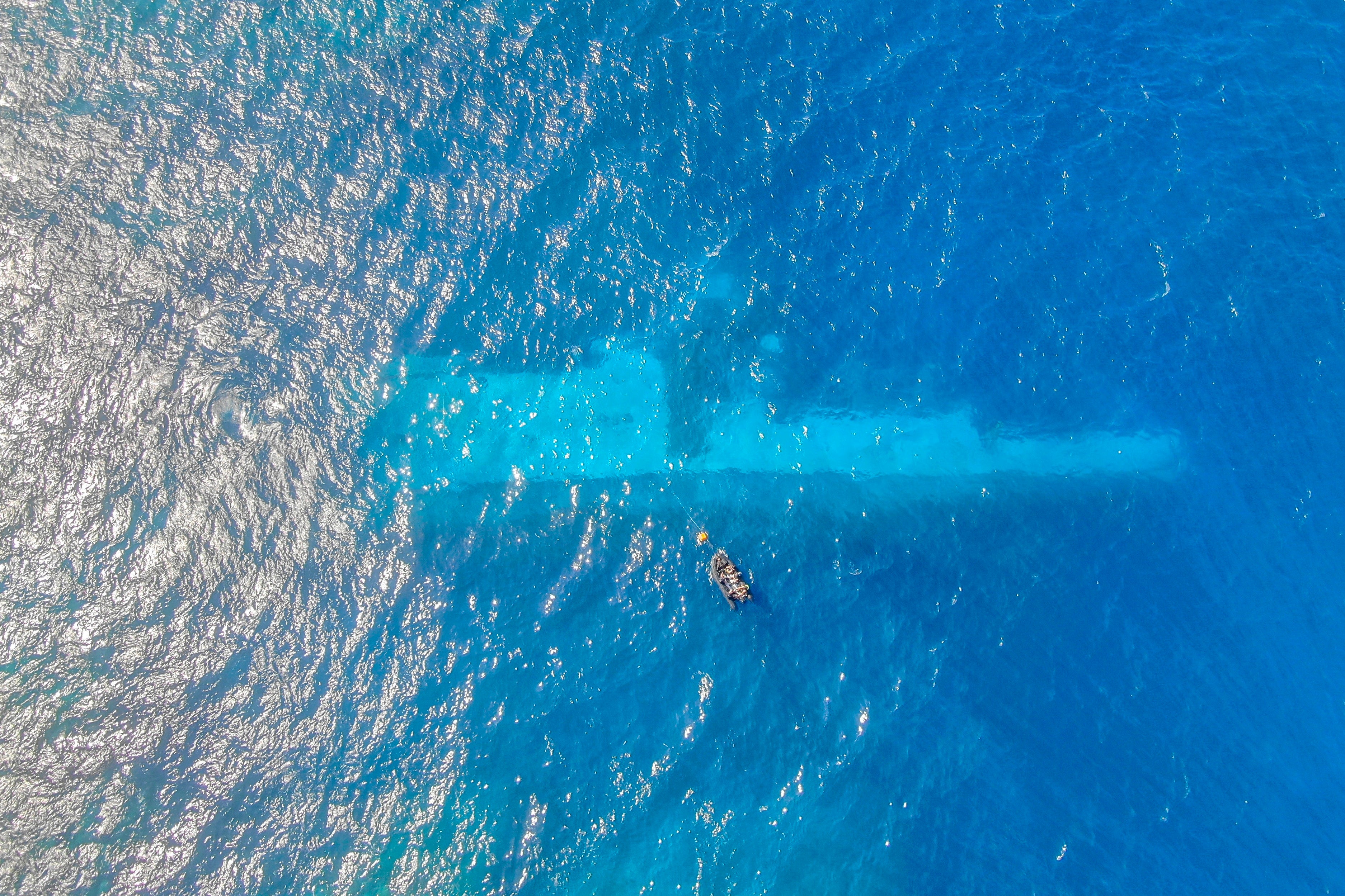 Divers survey the area around HMNZS Manawanui