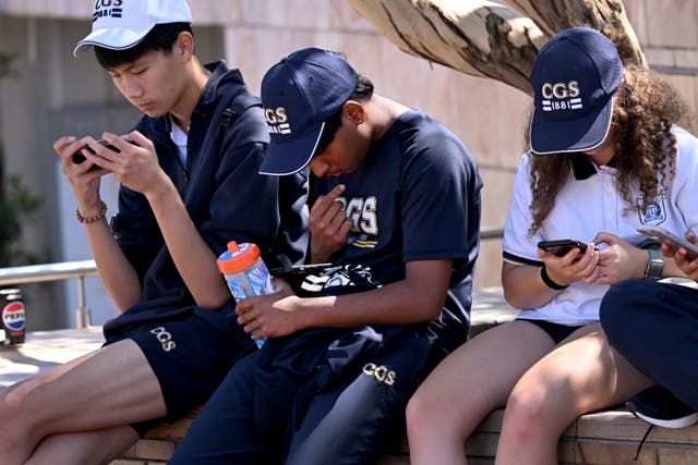 <p>File. Students look at their phones in Melbourne on 28 November 2024 </p>