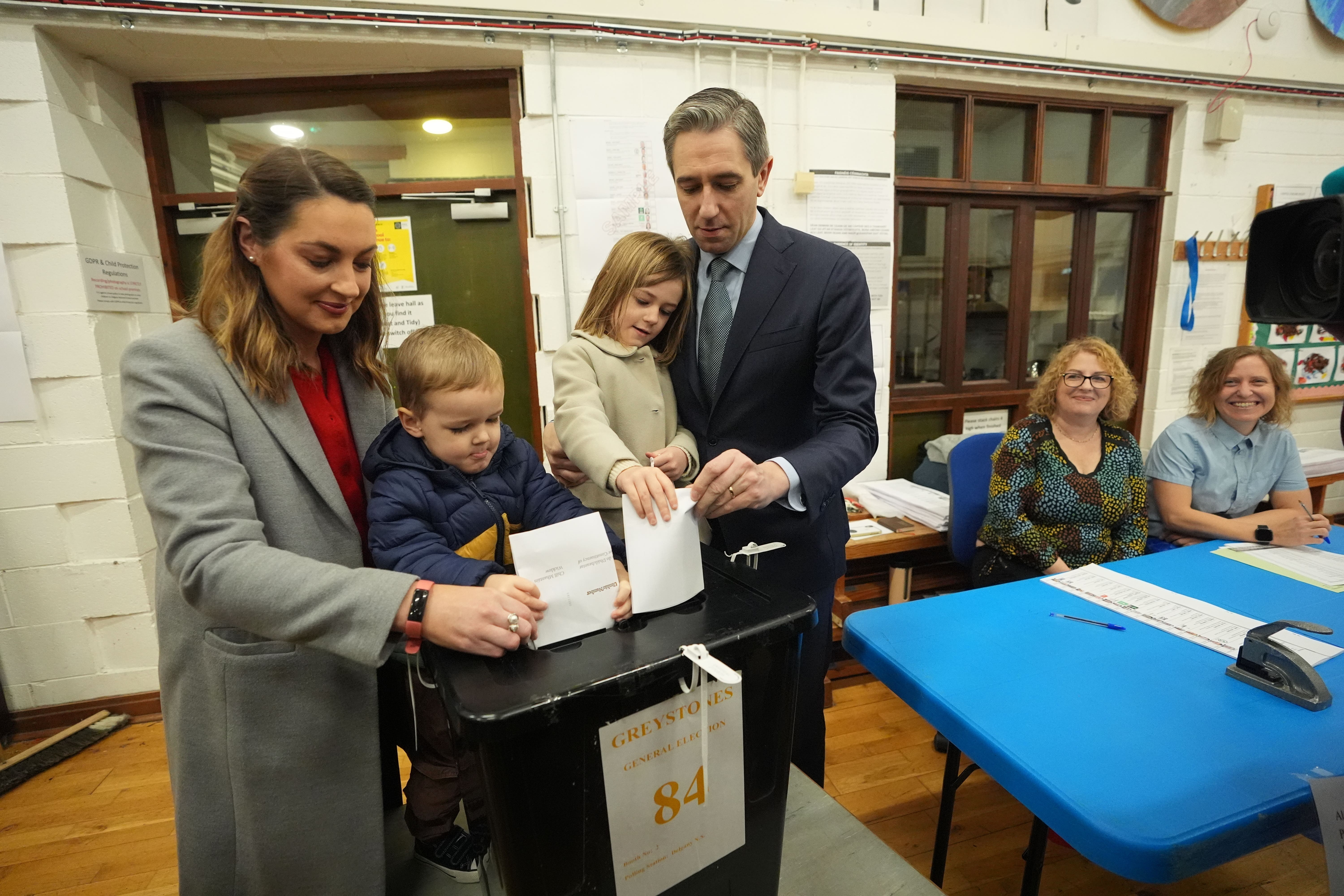 Taoiseach and Fine Gael leader Simon Harris accompanied by his wife Caoimhe and children Cillian and Saoirse as he casts his vote at Delgany National School (Niall Carson/PA)