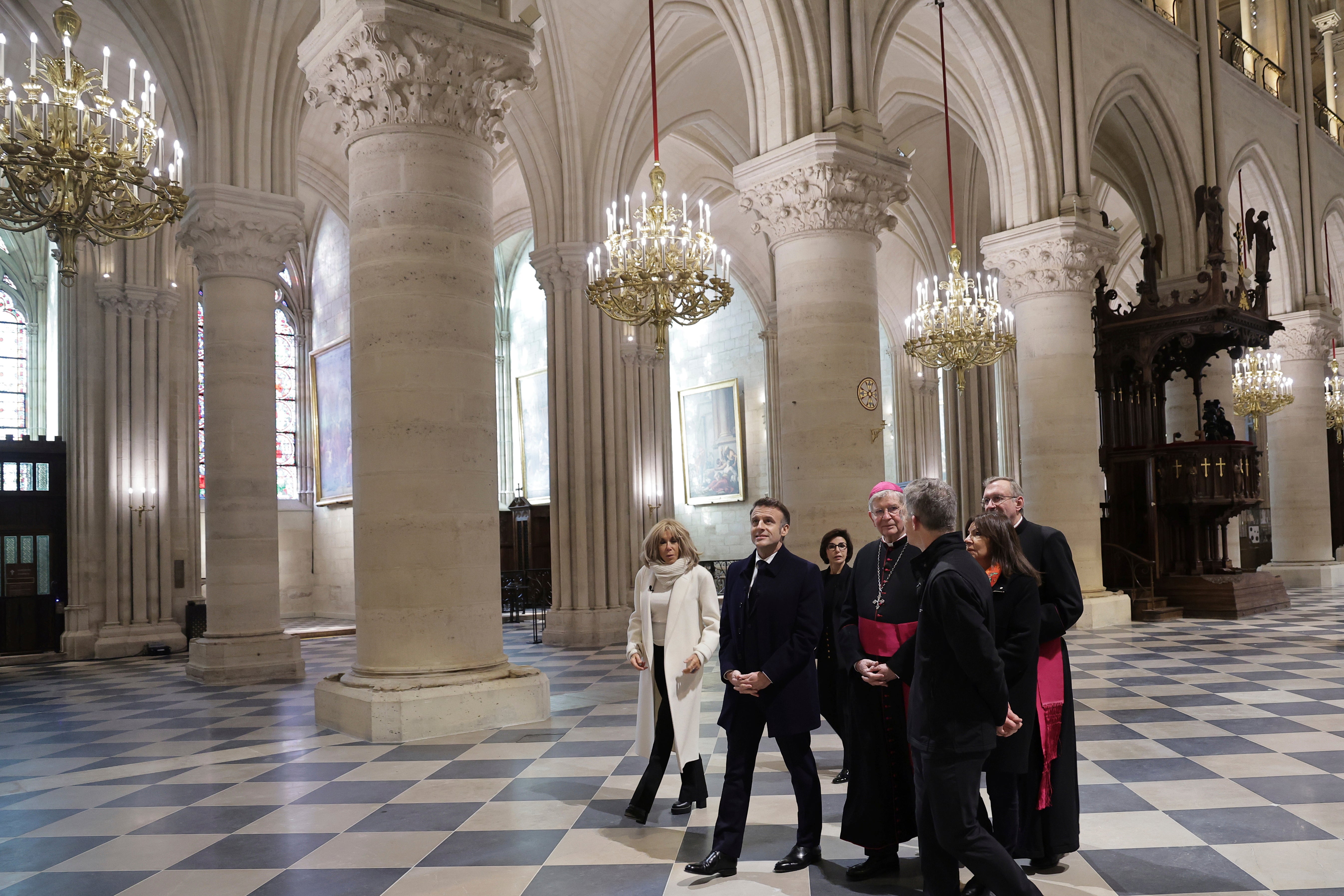 French president Emmanuel Macron (second left) and his wife Brigitte (left) visit the restored 12th-century cathedral