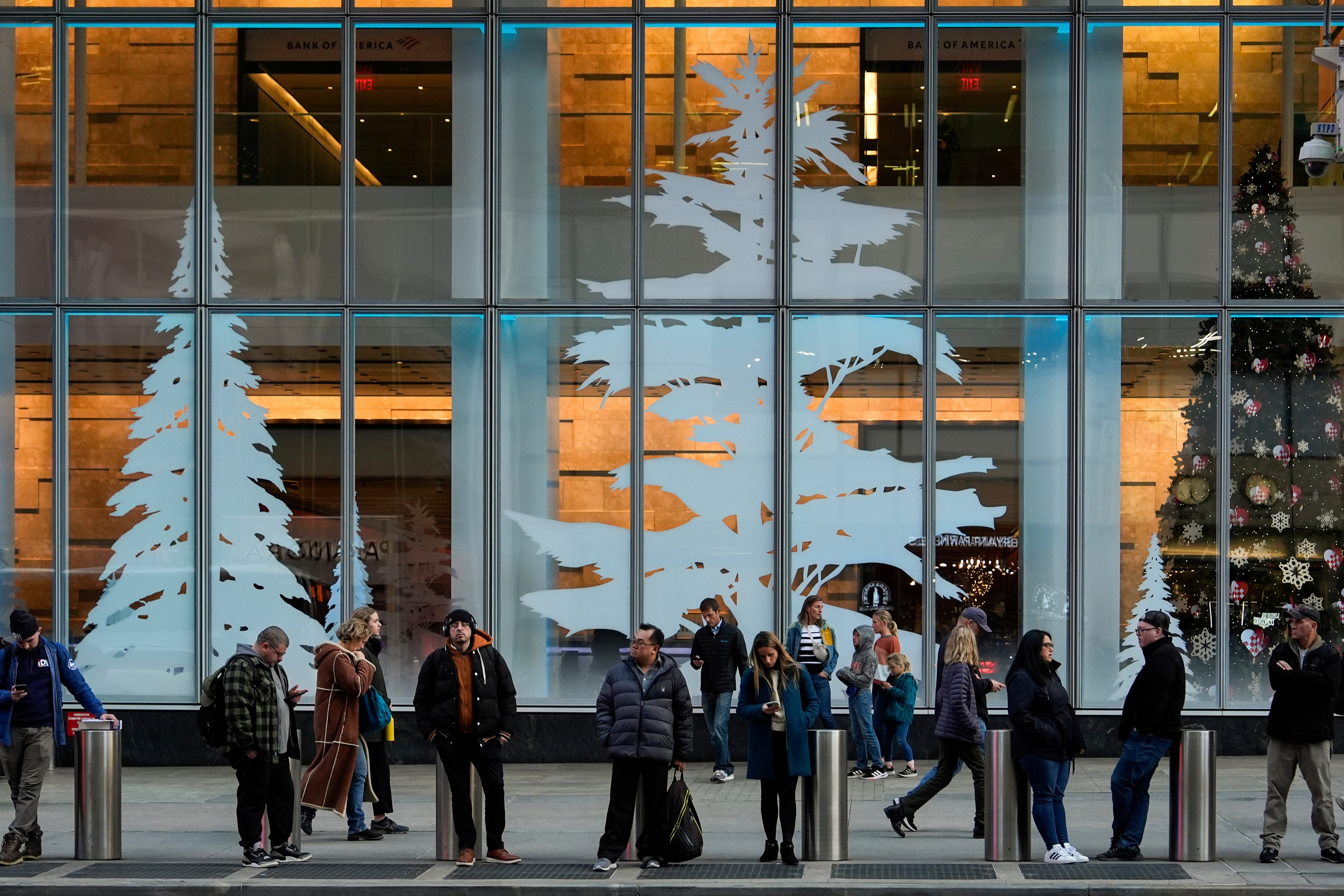 People wait on a sidewalk near Bryant Park’s Winter Village in New York City on Tuesday. The Big Apple will see its coldest beginning to December in years