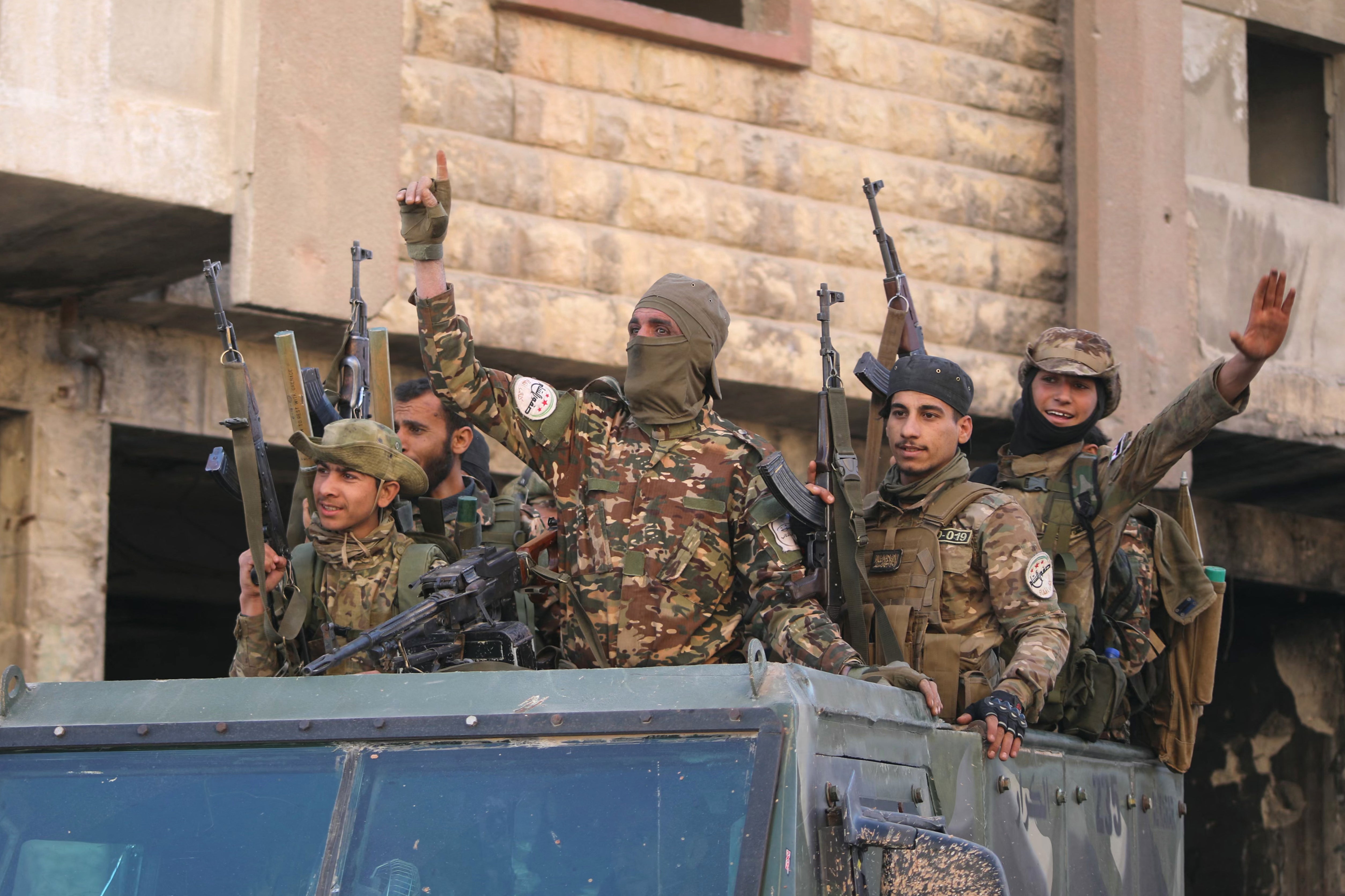 Anti-government fighters celebrate in a street in Maaret al-Numan in Syria's northwestern Idlib province