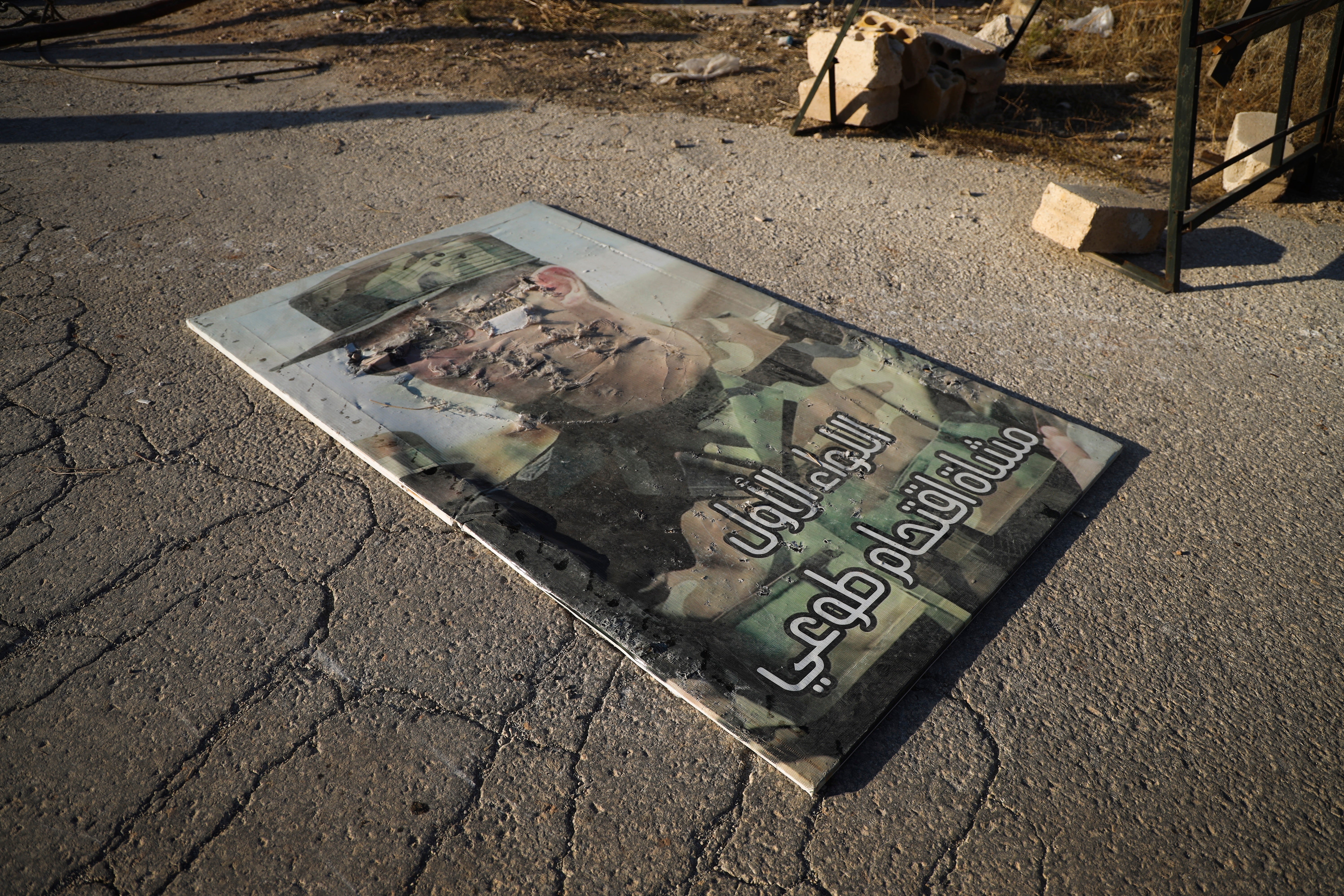 A defaced portrait of Syrian President Bashar Assad lies on the ground in the town of Maarat al-Numan, southwest from Aleppo