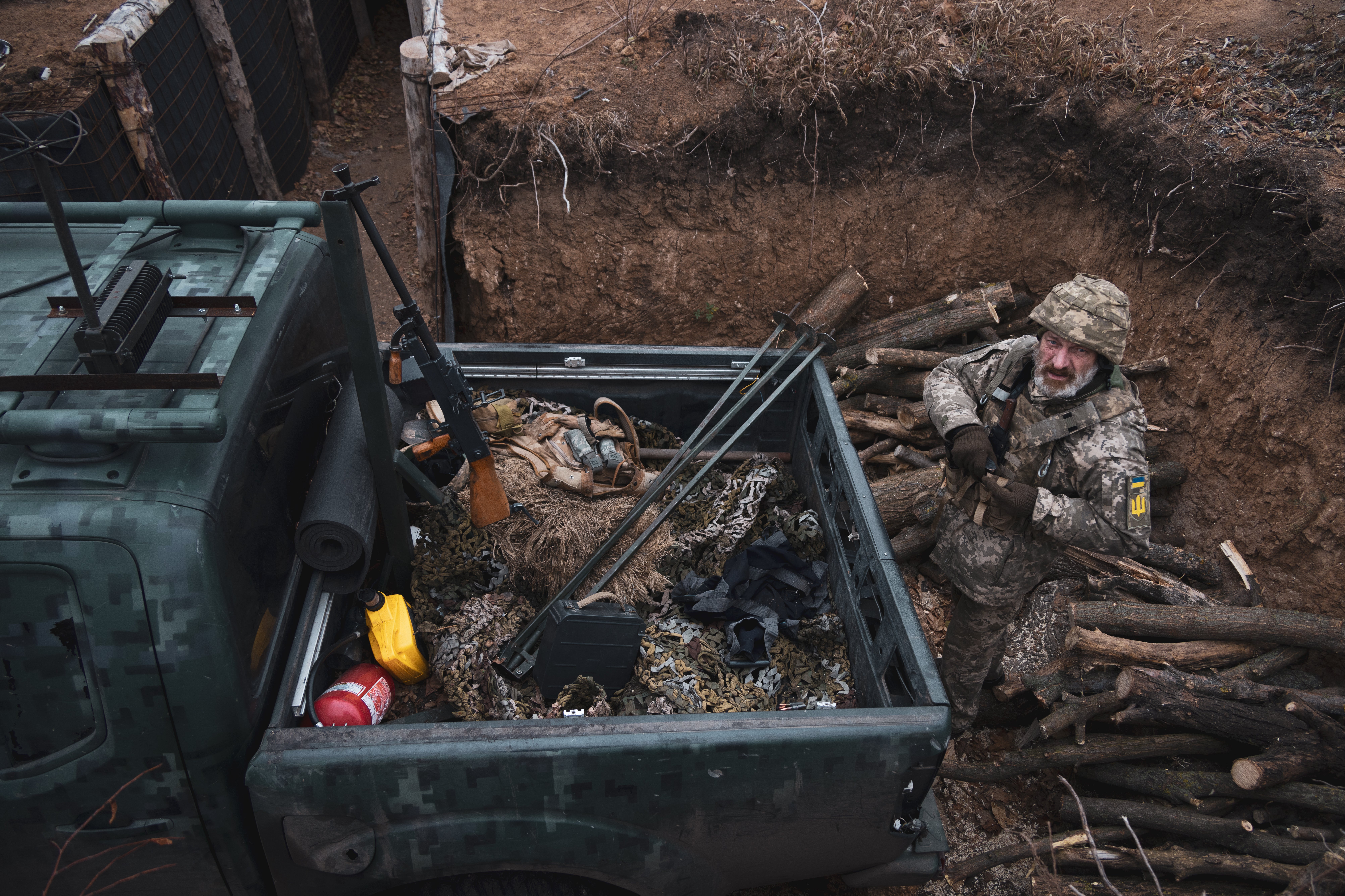 The commander of a mobile firing team of 118th motorised brigade prepares his machine gun to go on patrol and check for drones near the front line and the town of Orikhiv