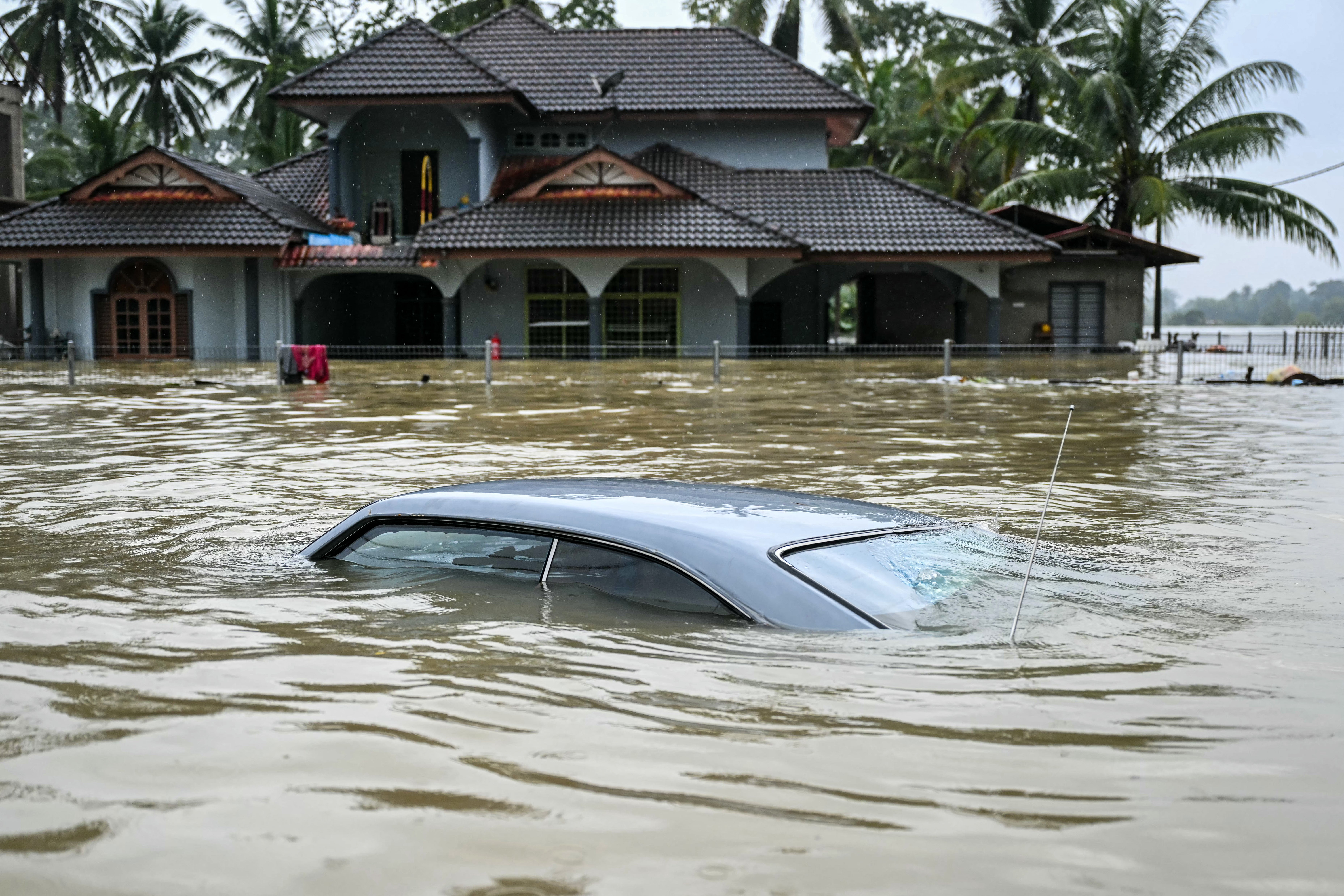 A car lies submerged after days of heavy rain in Tumpat in Malaysia’s Kelantan state on 30 November 2024