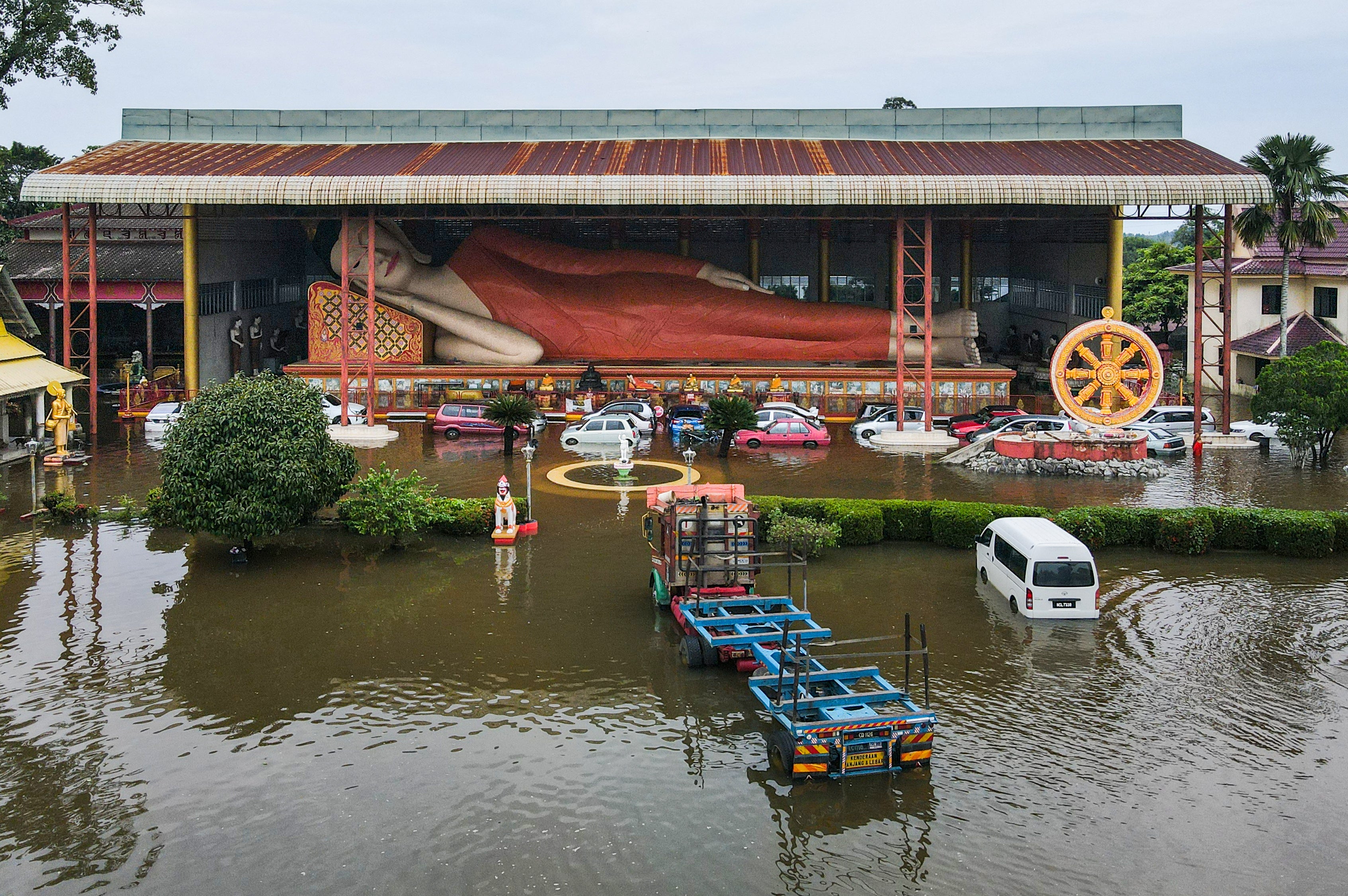 A reclining Buddha statue is surrounded by floodwaters after heavy rain in Tumpat