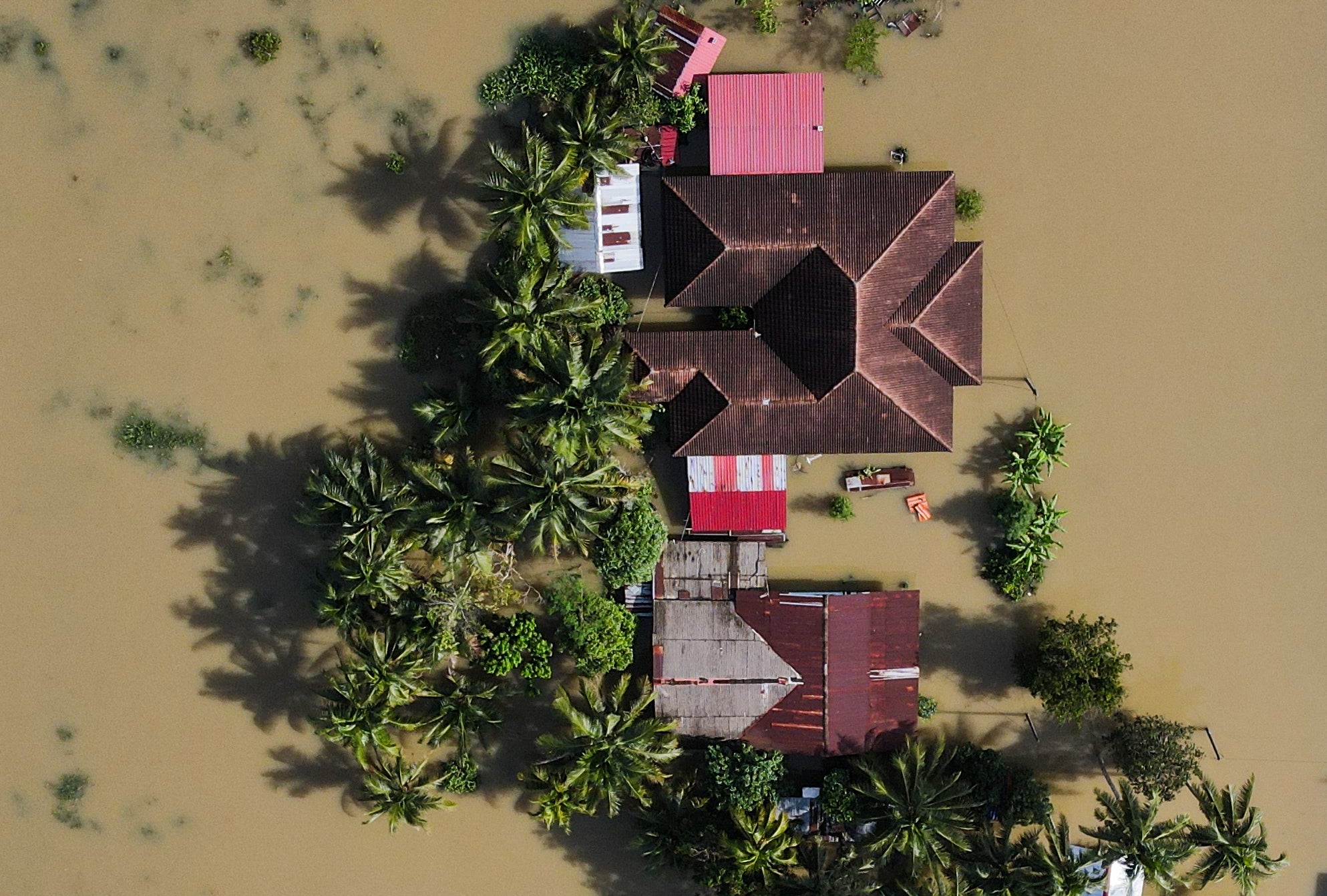 An aerial view shows houses surrounded by floodwaters after heavy rain in Tumpat in Malaysia on 2 December 2024